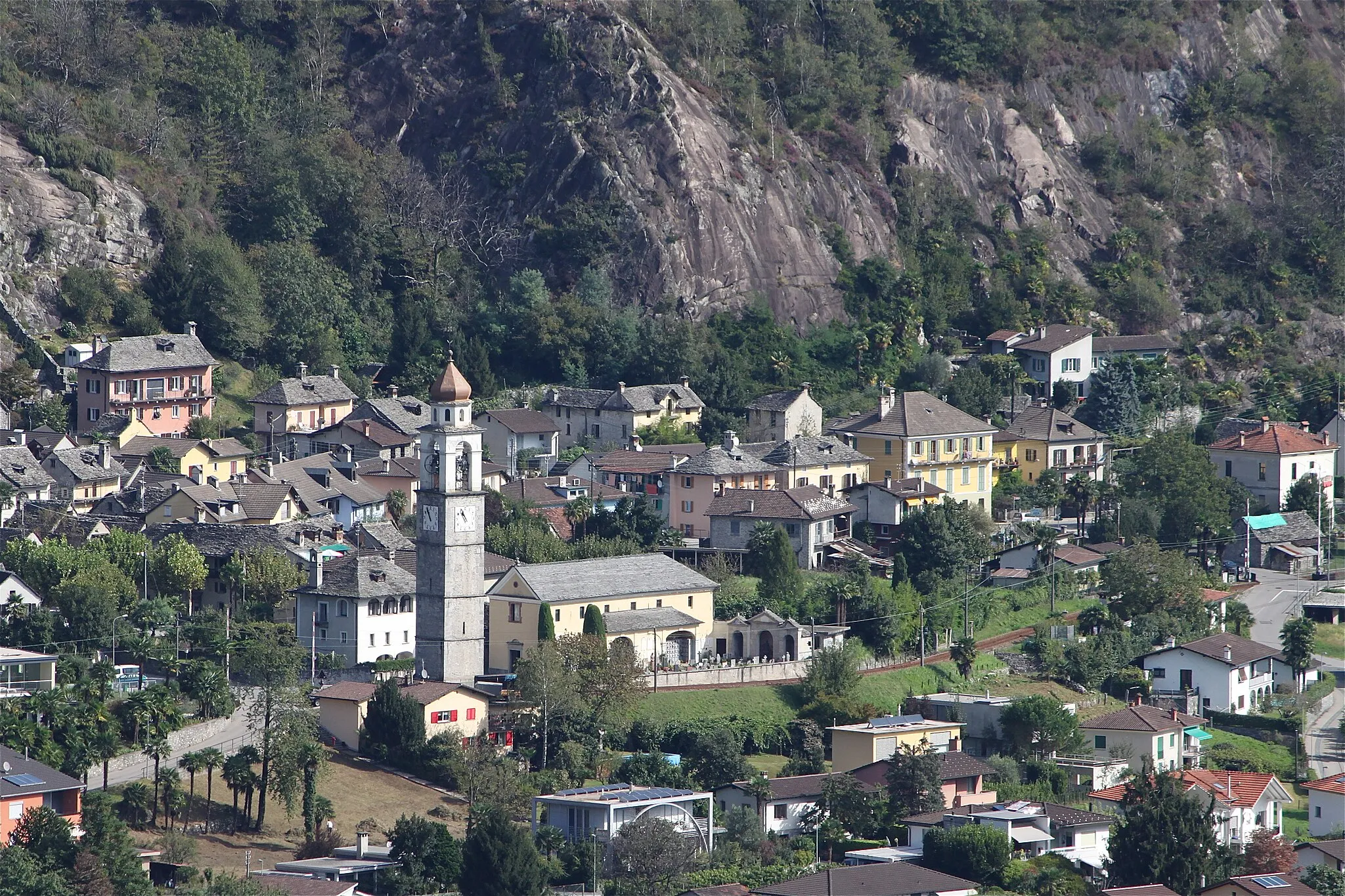 Photo showing: Veduta del Comune di Tegna con la chiesa parrocchiale di S. Maria Assunta.
