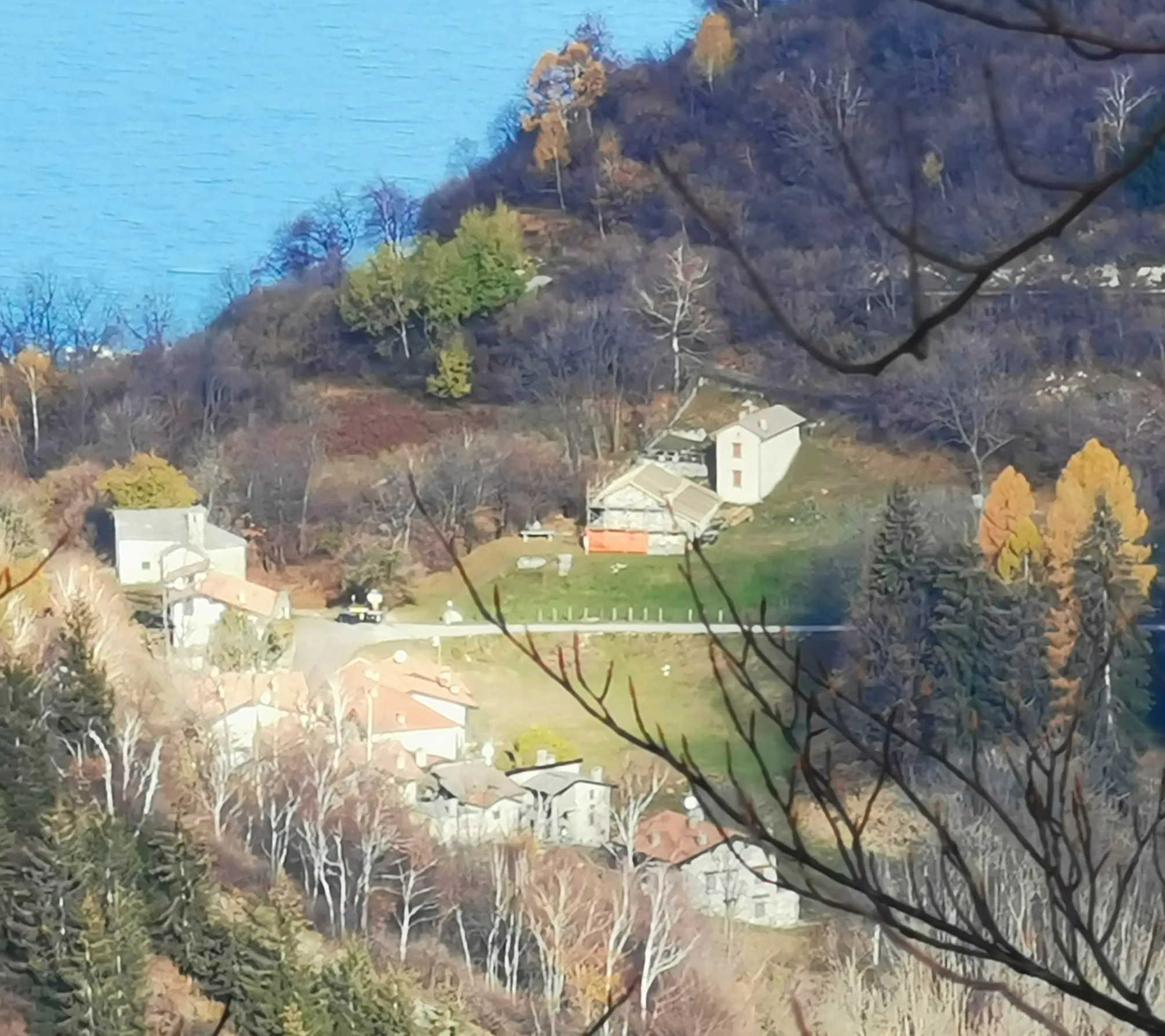 Photo showing: La frazione Alpe San Michele (Porto Valtravaglia), inquadrata dalla cima del Monte Ganna, sullo sfondo del Lago Maggiore.