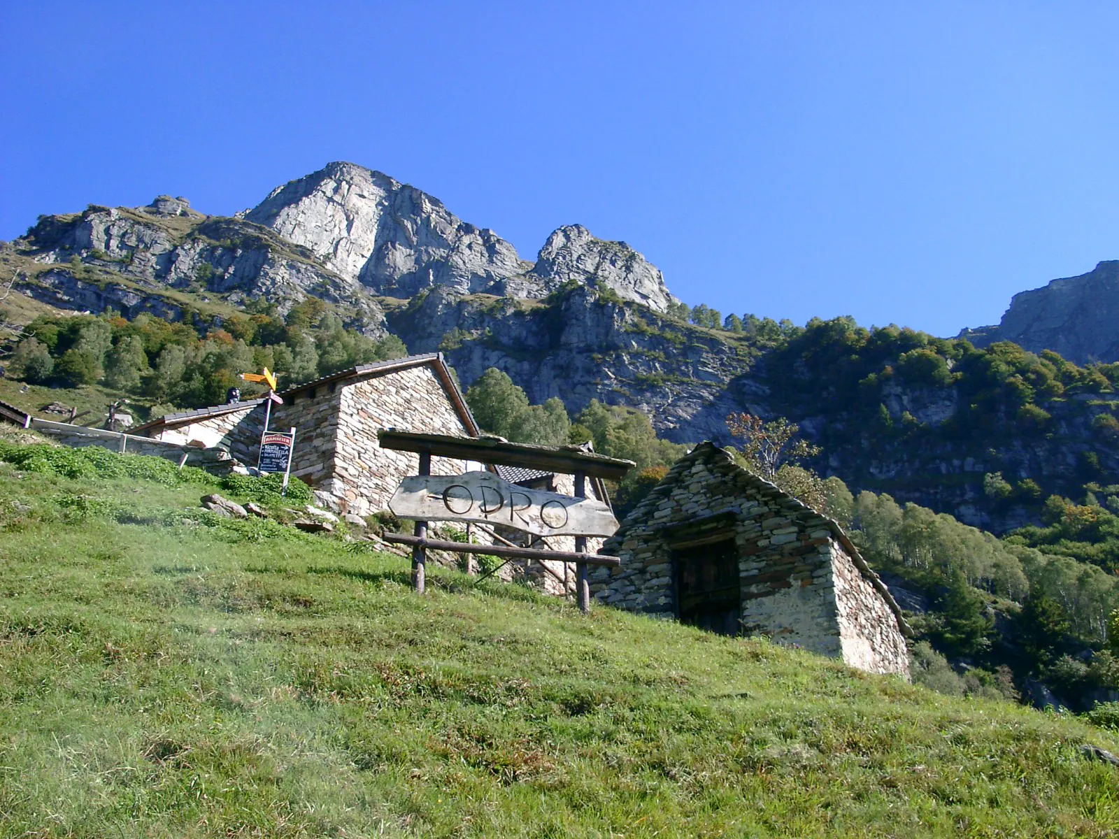 Photo showing: Blick zur Alp Odro. Odro ist eine Alp und Rustici-Siedlung (1240 m.ü.M.) oberhalb von Vogorno im Tessiner Valle Verzasca. Von Odro aus bietet sich ein atemberaubender Ausblick auf die Tessinerberge und auf einen Teil des Lago Maggiore.
