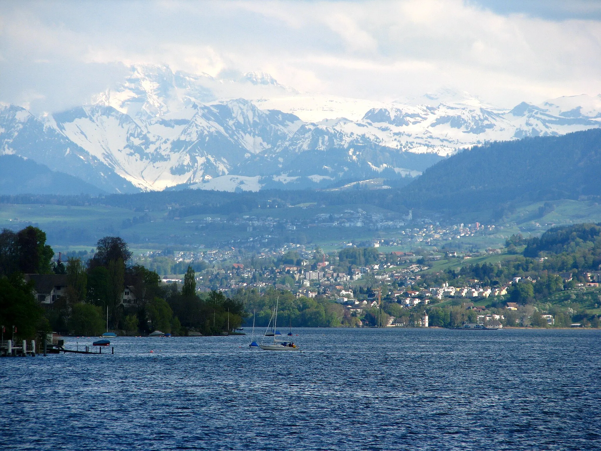 Photo showing: Zürichsee (Lake Zürich) : Au peninsula at Au (ZH), Wädenswil, southeasternly Zimmerberg plateu and Alps in the background.