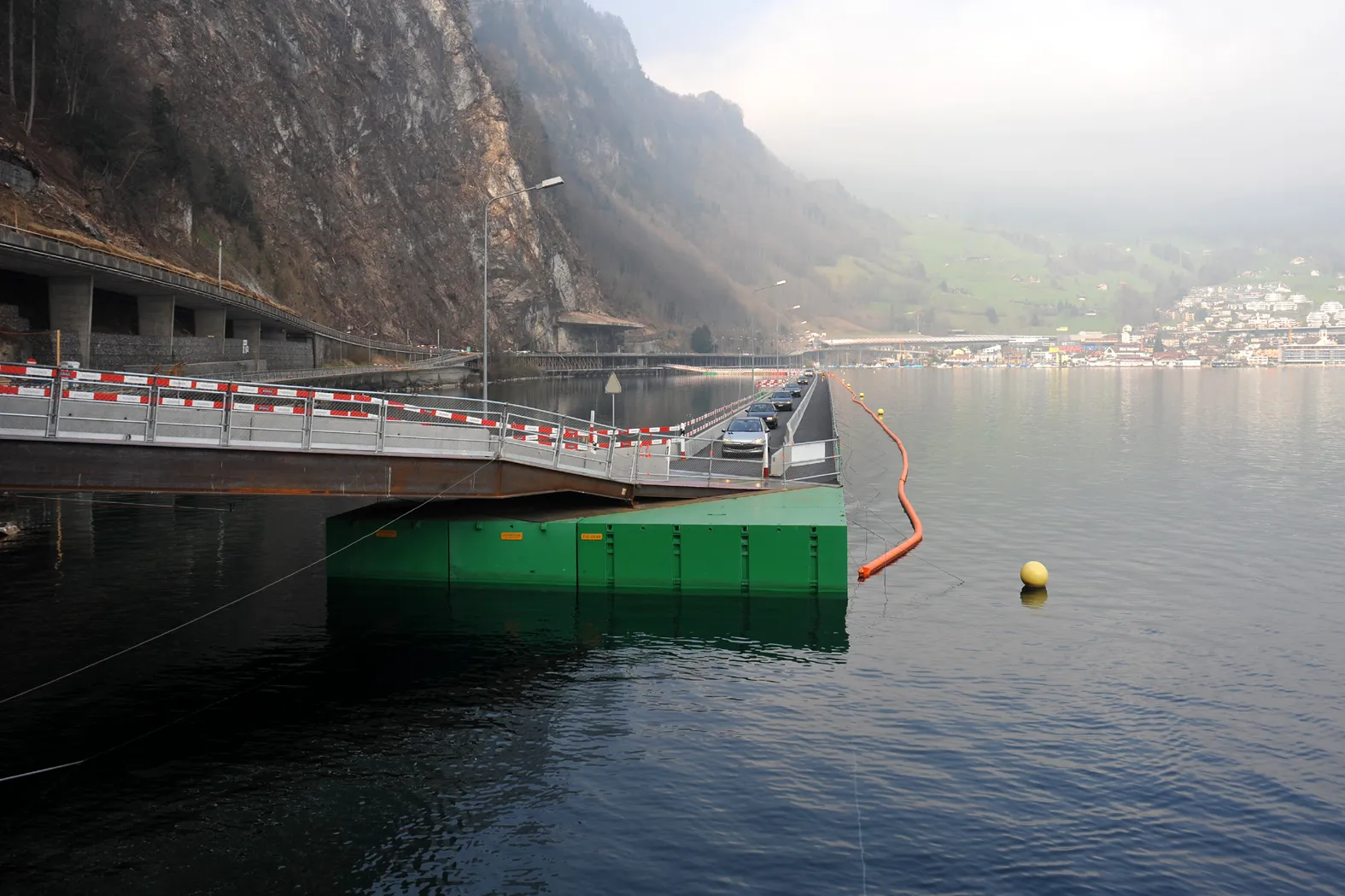Photo showing: Pontoon temporary bridge at the Lopper northern hillside; Nidwalden, Switzerland.
Frequently rock break offs forced authorities to close the road along Lopper 12 October 2009. From 31st March 2010 till 13th May 2011 the traffic was led over an approximately 500 m long pontoon bridge which was unique in Europe.