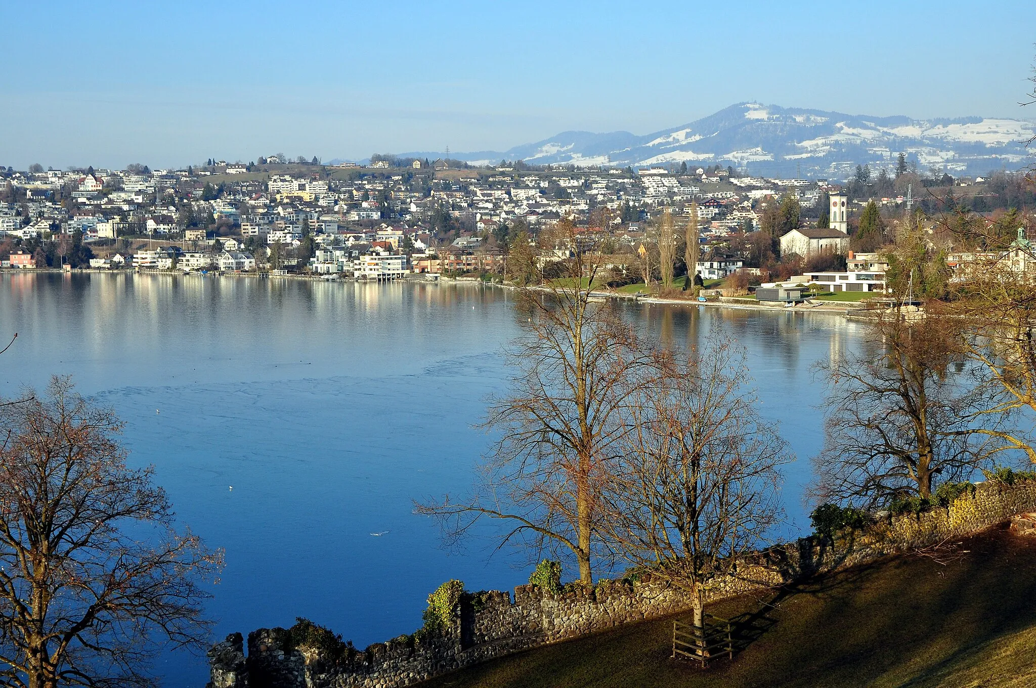 Photo showing: Kempraten on Zürichsee in Switzerland, as seen from Lindenhof hill in Rapperswil (Switzerland), Bachtel in the background.