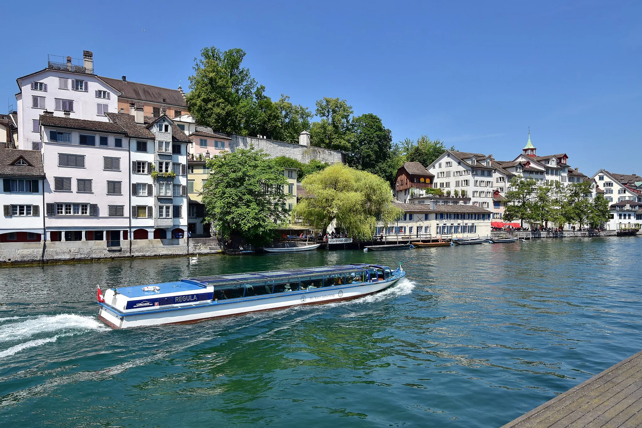 Photo showing: Schipfe and Lindenhof hill at Rathausbrücke (Gmüesbrugg) as seen from Limmatquai in Zürich (Switzerland), Zürichsee-Schifffahrtsgesellschaft (ZSG) Limmat boat Regula driving downstreams Limmat river.