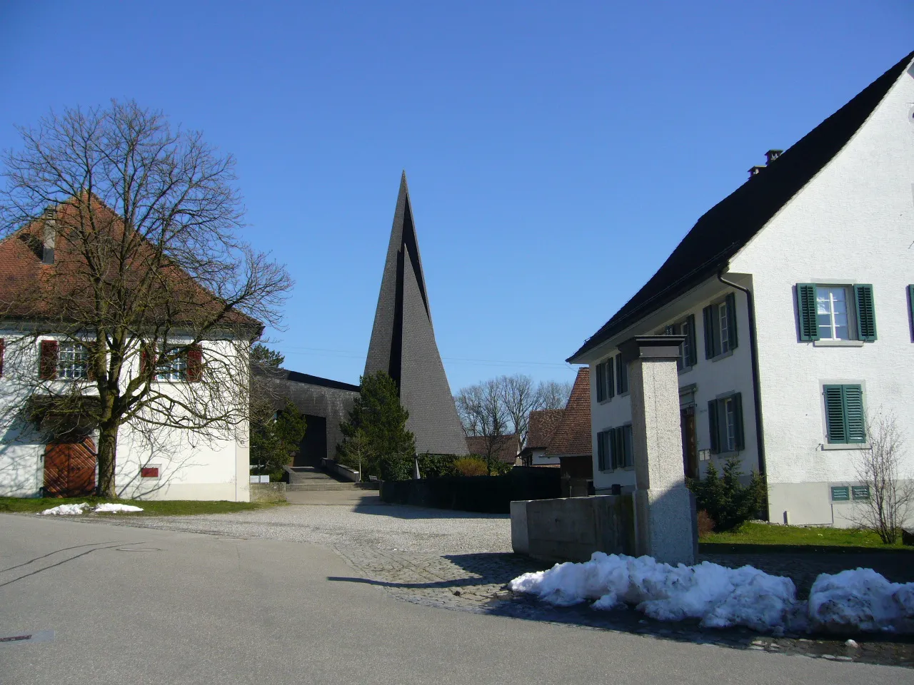 Photo showing: Roman Catholic church and rectory (left) in the village of Hüttwilen, canton Thurgau, Switzerland. Picture taken by Peter Berger, March 26, 2007.
