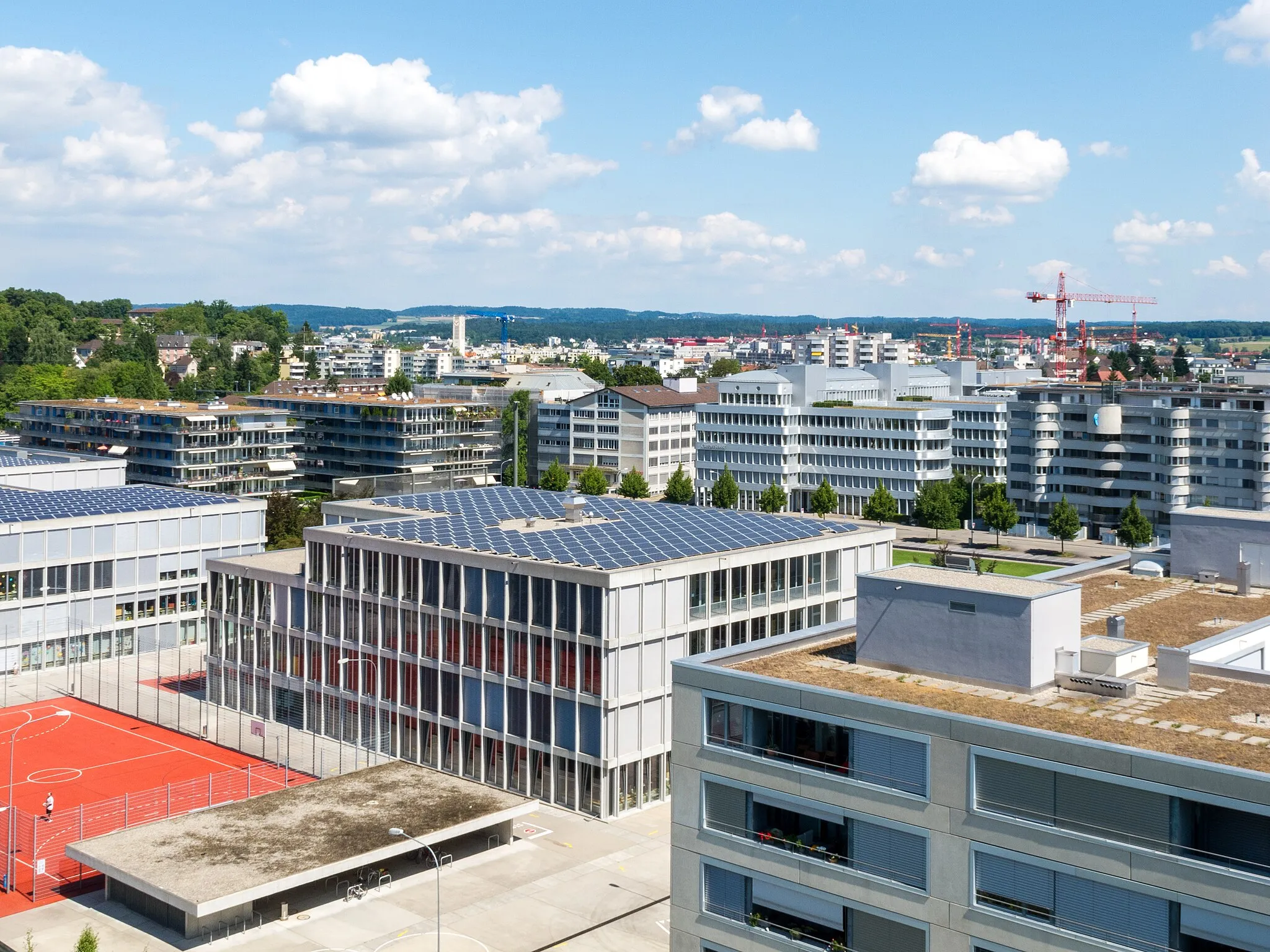 Photo showing: Neu-Oerlikon (Zürich): Blick vom Turm im Oerlikerpark zum Schulhaus im Birch und Wohn- und Wohn- und Bürohäusern u. a. an der Ruedi-Walter-Strasse.