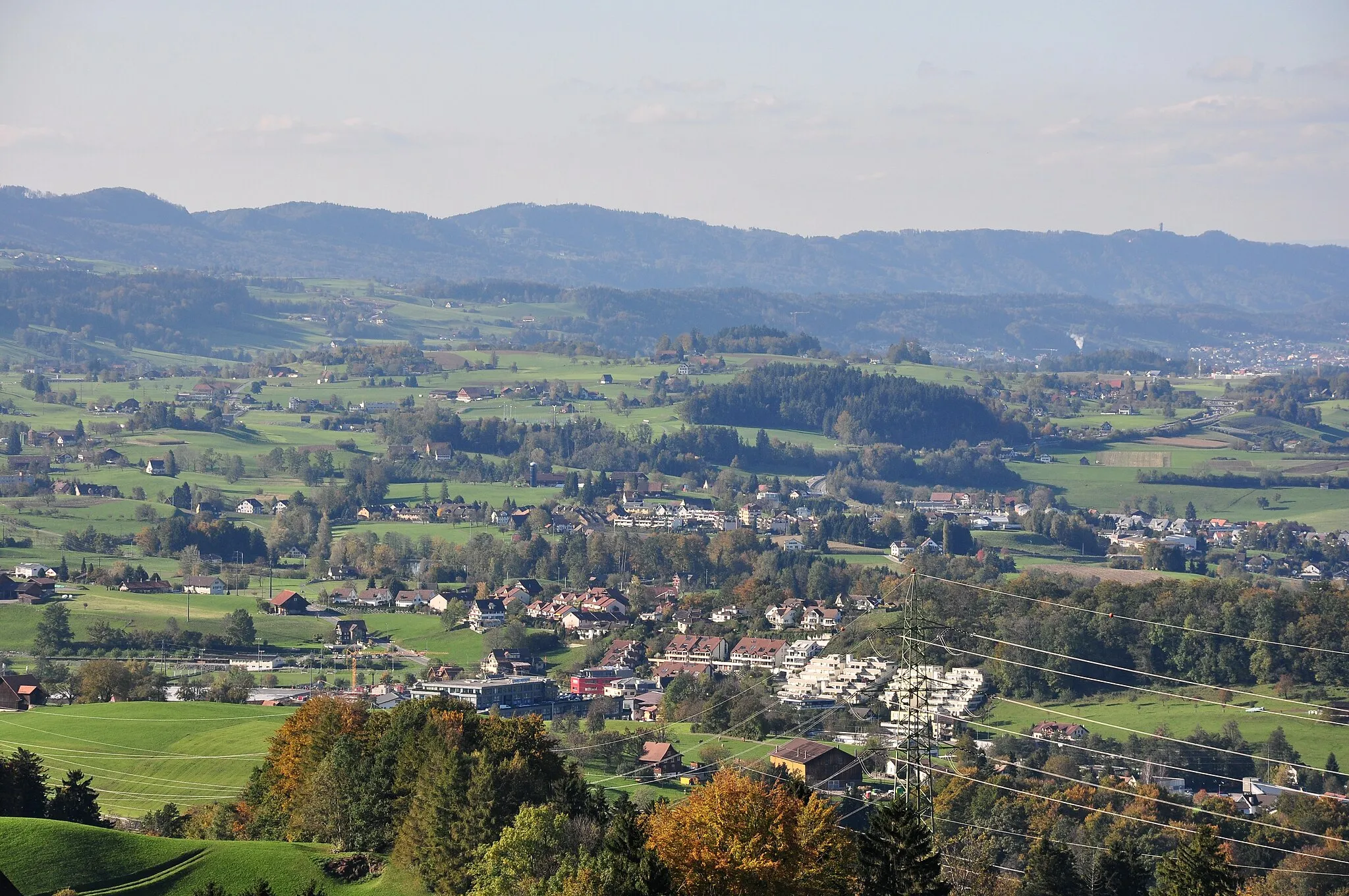 Photo showing: Samstagern and Wollerau (separated by the highway) on Zimmerberg plateau, as seen from Feusisberg (Switzerland) towards Etzel mountain, (from the left:) Albis chain with Felsenegg and Sihltal valley in the background.