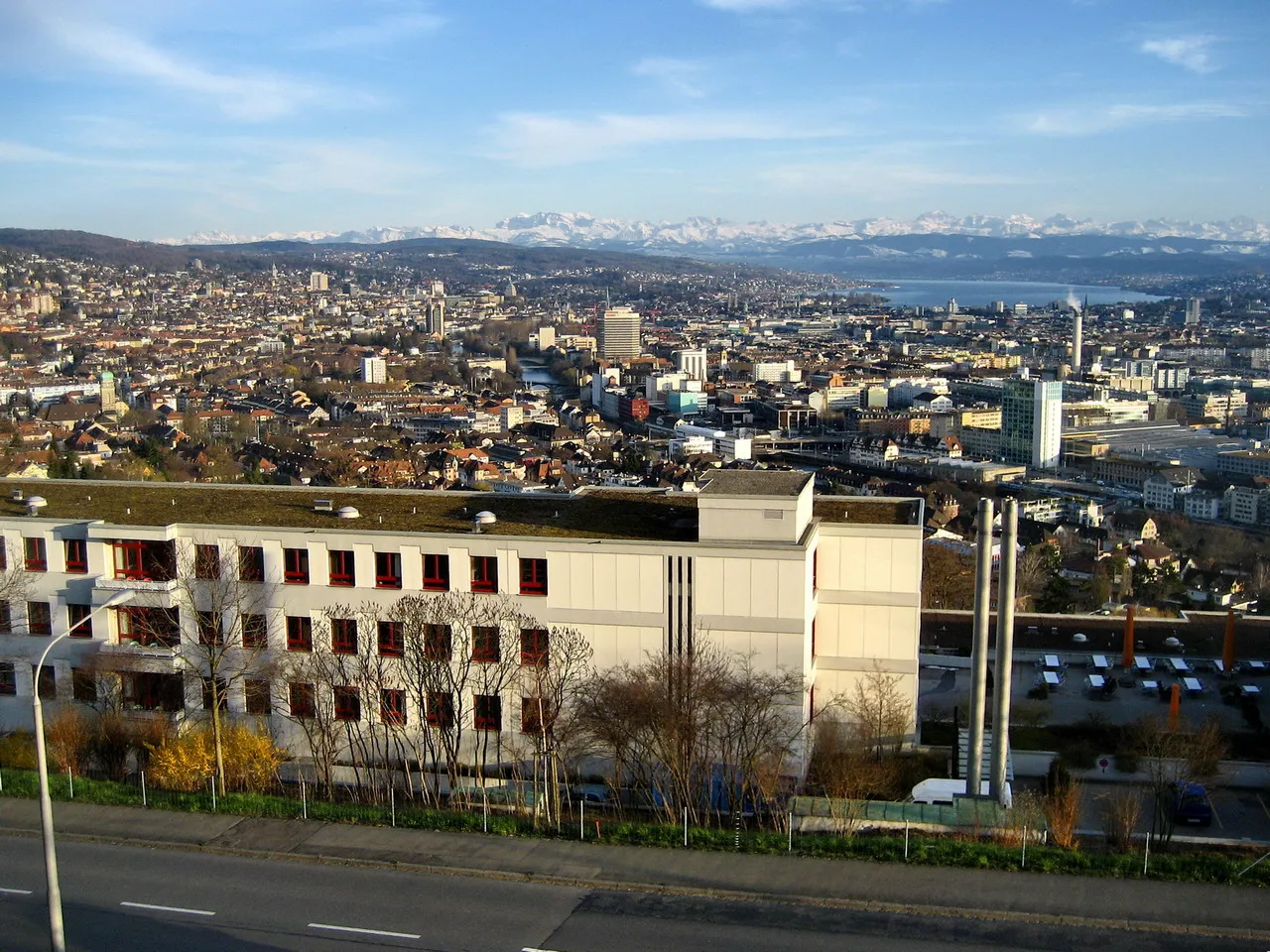 Photo showing: Zurich : City of Zürich, Adlisberg (to the left), Pfannenstiel (in the middle to the left), Zürichsee (Lake Zürich), Zimmberberg (to the right) and Glarus Alps, as seen from Käferberg-Waidberg hills.