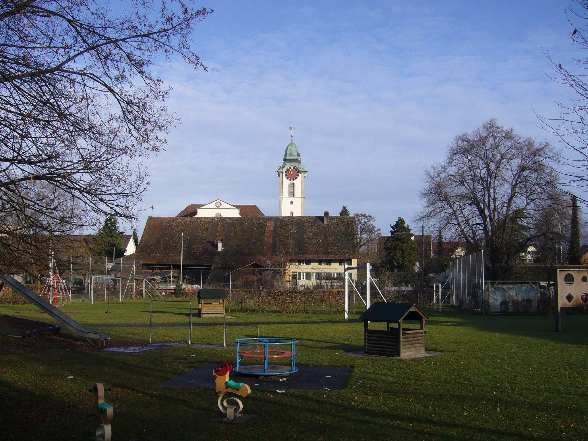 Photo showing: Blick vom Altbache auf Bauernhaus bei der reformirten Kirche; im Vordergrunde ein Spielplatz.