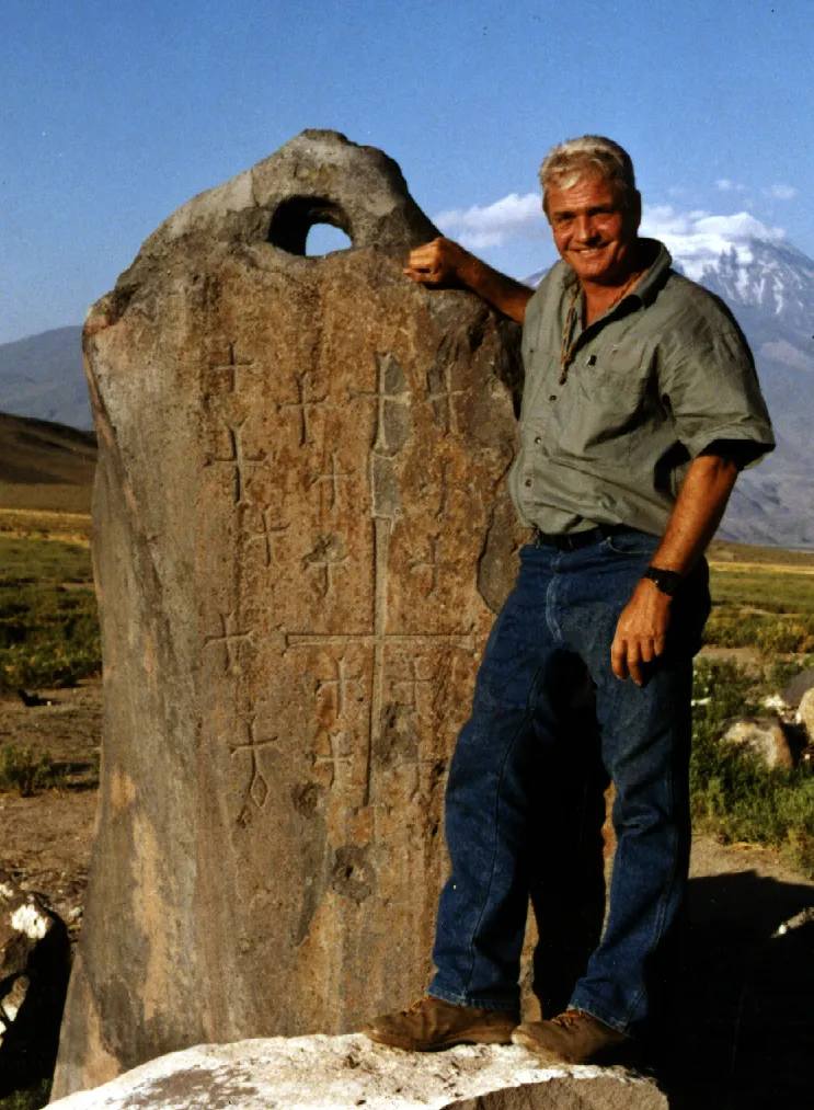 Photo showing: David Fasold, a promoter of the Durupınar site, stands with a Drogue Stone in Arzap ((Kazan) Türkiye) (crosses are believed to have been added later)