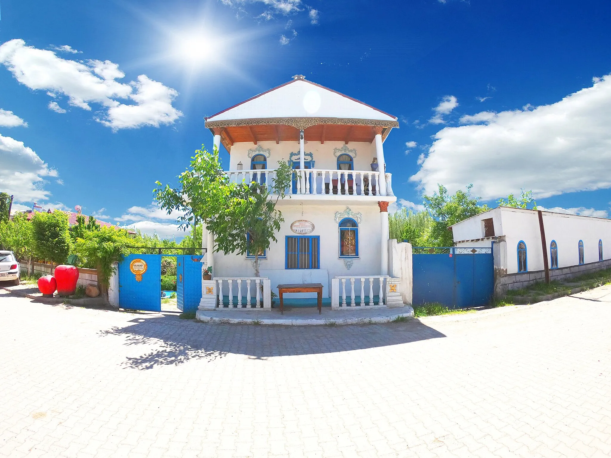 Photo showing: ATA OCAĞI:  ığdır Merkeze bağlı Melekli Köyünde bulunan Ata Ocağı kültür sanat evi köyün geçmişini yansıtan önemli ev eşyalarının sergilediği özel etnografya müzesi niteliğinde bir mekan. Doğa düşkünlerinin en çok ziyaret ettiği yerler arasında bulunan Nuh’un İzinde Gezi  parkuruyla Sanat sokağının başladığı noktada bulunan  bu kültür sanat evi sanatı hayatla özdeş tutan özgün ve çağdaş müze algısının parçasıdır.
Nuhun izinde gezi parkuru sonrası  uğrayacağınız en güzel yerlerden birisi olan Ata ocağı Kültür ve sanat evinde; Iğdır yöresi ve Türk boylarına özgü giyim ve kuşamların yanısıra  ev eşyaları, eski tarım aletleri, halılar, nazarlıklar, heykeller ve bu bölgede yaşamış bir çok uygarlığın izlerini yansıtan objeler yer alıyor.
Iğdır yöresinde Ata ocağı yada Balahana olarak adlandırılan bu evler yöreye has özgün mimariyi yansıtmakla birlikte, dededen  kalma bir kutsal miras olarak kabul edilmekte ve gelecekte bu ocaktan dağılan herkesin bir araya yeniden gelebilecekleri bir mekan olarak kabul etmektedirler.

ATA OCAĞI: Kimi insan uzun yılların sonunda doğduğu topraklara dönmek ister, geçmişine çocukluğuna ve anılarına döner gibi ve o doğup büyüdüğü sokaklara, arkadaşlarına borç ödemek ve selam durmaktır amaç. Aslında mutluluğun ve  sırrıda geçmişle buluşmak çocukluk yıllarına dönmek değilmidir. insan hikayelerini hatırlar saçar ortalığa geçmişiyle buluştuğunda. Zaten insan dediğin yol ve hikayeden ibaret değilmidir. Bu kez yolculuğumuz Ağrı dağının eteğinde yalnız bırakılmış, kendi deminde yeşerip solan bir köy. Aras dağları silsilesini geçtikten sonra yemyeşil bir ova karşılar sizleri, Nuh’un bereketli toprakları diğe anılan bu uçsuz ovayı gördüğünüzde önce bir boşluk sarmalar ve ileriye doğru baktığınızda göğü perde perde delip gökyüzüne doğru yürüyen yeryüzünü yani “Ağrı dağını” görürsünüz karşınızda. Tüm ihtişamıyla kol kanadını Iğdır ovasına açmış koruyucu bir ana gibi sanki sizleri gözetliyor. Geceyle gündüzü barıştıran bu dağın püskürttüğü lavların eteğinde Mistik bir köy karşılar sizleri. Tarihi oldukça geçmişe uzanan bu köyün İnanışa göre Tufan sonrası Nuh’un ektiği fidelerle yeşerdiği söylenmektedir. Köyün ismine dair  farklı söylemler vardır. Bir rivayete göre, köyün Selçuklu hükümdarı Melikşahın Ani’yi fethederken burada konakladığı ve ismini Melikşahtan (Melikli) aldığı yönündedir. Ayrıca bu köyde Selçuklular, Karakoyunlular, Akkoyunlular, İlhanlılar, Urartular ve Yontma taş devri dönemlerinden kalma bir çok kalıntıları da görebilir  tarihsel olarak oldukça geriye gidebilirsiniz.

Iğdır merkezden 4 km uzaklıktaki bu Köyde gezip görülecek pek çok farklı nokta vardır. Bunların bilincinde olarak gezmeniz, size daha keyifli bir gezi sağlayacaktır. Örneğin; Ata Ocağı kültür sanat evi, Sanat sokağı, Nuh’un izinde gezi parkuru, İrem bağları, Kültepeden Ağrı dağına uzanan eski ipek yolu,  Akkoyunlu açık hava müzesi, Iğdır Soykırım anıt müze, Tarihi gırğın mezarlığı en çok görülmesi gereken yerler arasında. Köyün çaybaşı camisinde bulunan tarihi kütüphaneside unutulmamalıdır.