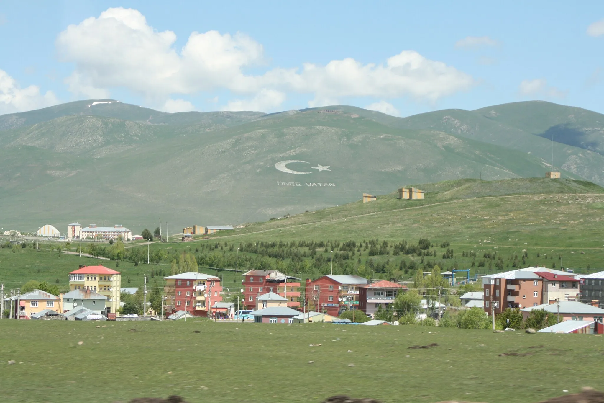 Photo showing: ქალაქ არტაანის ნაწილი, მთაზე გამოკვეთილი ნახევარმთვარისა და წარწერის "წინ სამშობლოვ" ფონზე.