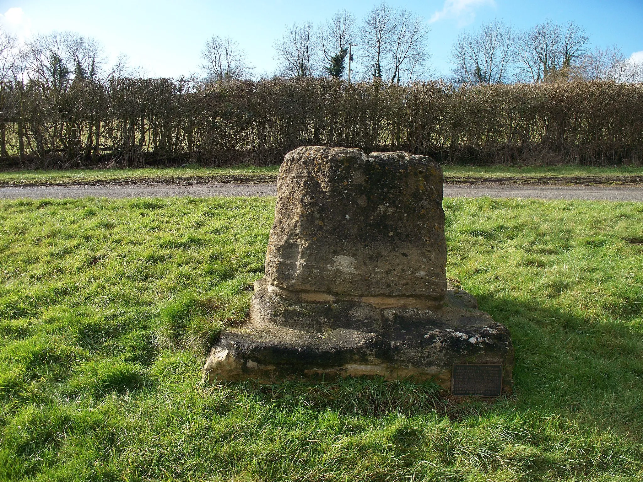 Photo showing: Base and broken shaft of a 14th- of 15th-century stone cross in Lower End, Salford, Oxfordshire. It used to stand beside the A44 main road about 20 metres south of Mount Pleasant. It bears a plaque that says it was moved to its current site in 2003.
