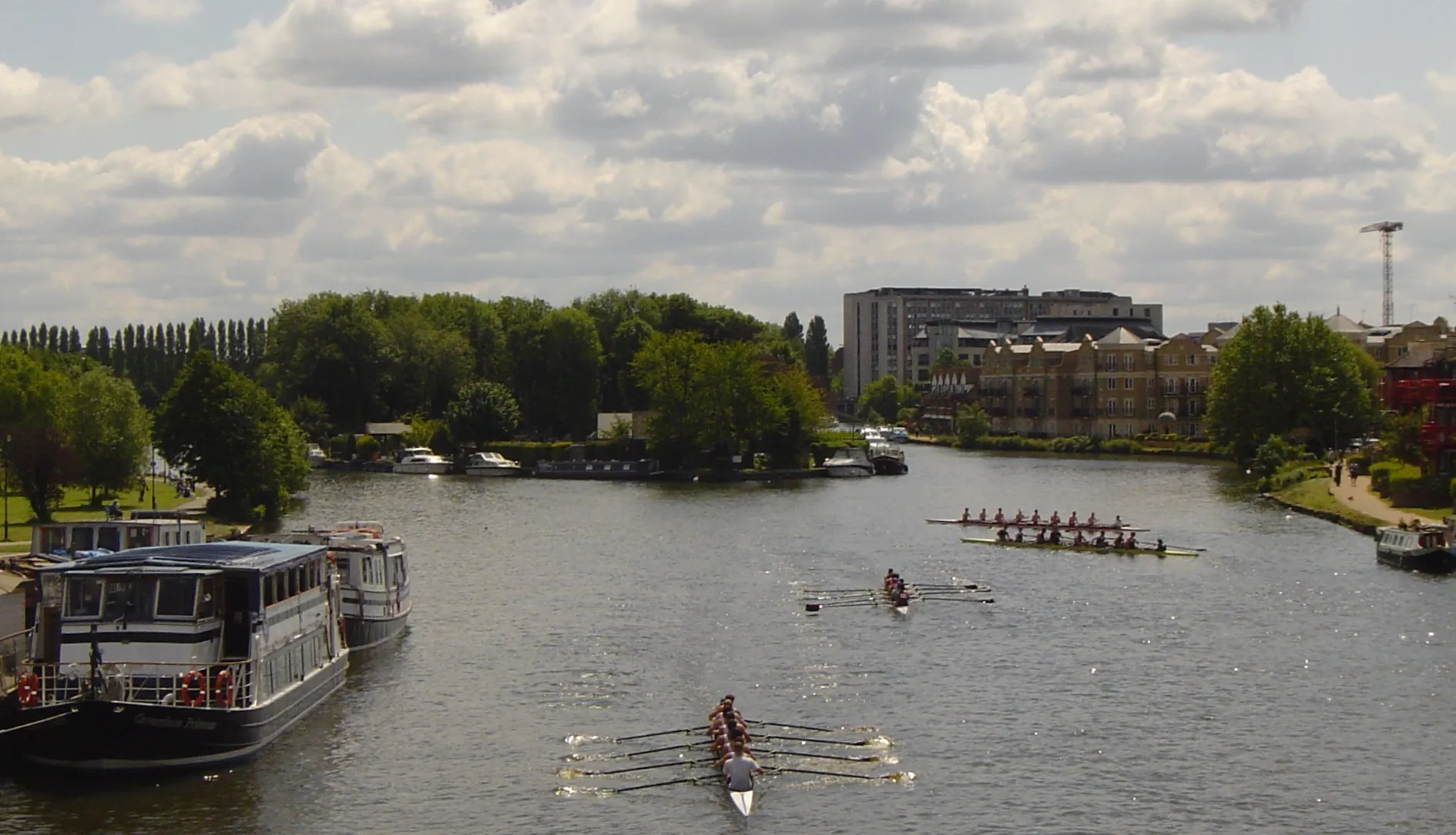 Photo showing: The River Thames, looking downstream from Caversham Bridge in the English town of Reading. Pipers Island and its restaurant is to the immediate left, the upstream end of Fry's Island can be seen downstream separating the two channels.  For more information see the Wikipedia articles Pipers Island and Fry's Island.