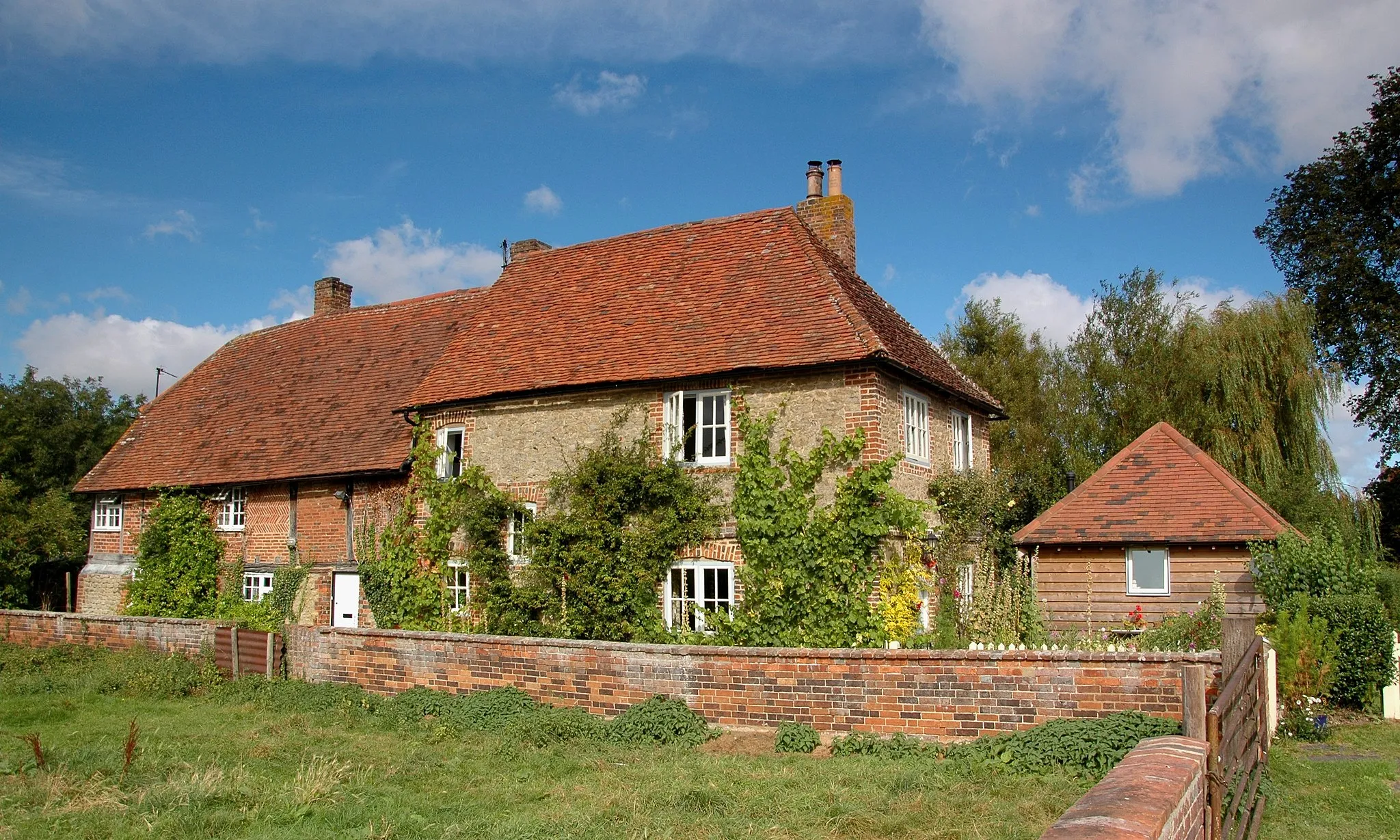 Photo showing: Sydenham, South Oxfordshire: 17th century (left) & 18th century (right) cottages. The 17th century cottage is timber-framed with brick nogging; the 18th century cottage is coursed rubblestone.