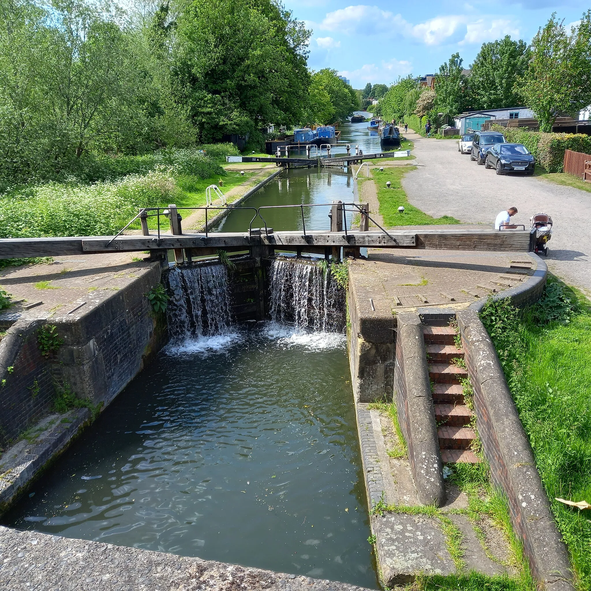 Photo showing: Apsley Middle Lock (Lock 66) on the Grand Union Canal in Apsley, Hertfordshire, looking north towards Apsley Top Lock (Lock 65) and beyond that, Hemel Hempstead. Taken from the footbridge by the Apsley Mills Sainsbury supermarket.