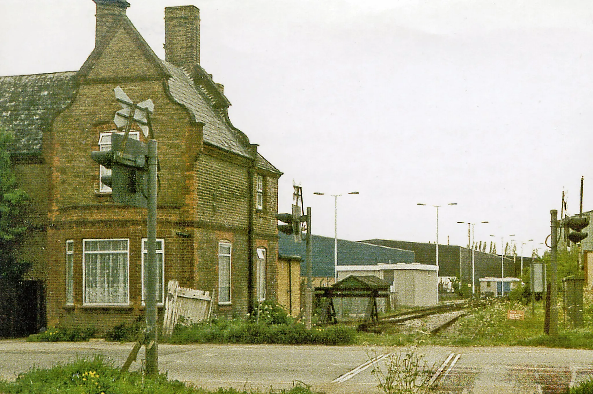 Photo showing: Site of Colnbrook station, 1986,
View northward across the B3378 (original Bath Road), towards West Drayton: ex-GWR West Drayton - Staines branch. The station was closed when the passenger service on the branch ceased from 29/3/65. Goods traffic ceased from 3/1/66, but as the photograph shows the line remains open to this point from West Drayton, for traffic to a fuel depot for Heathrow Airport and to an aggregates depot.