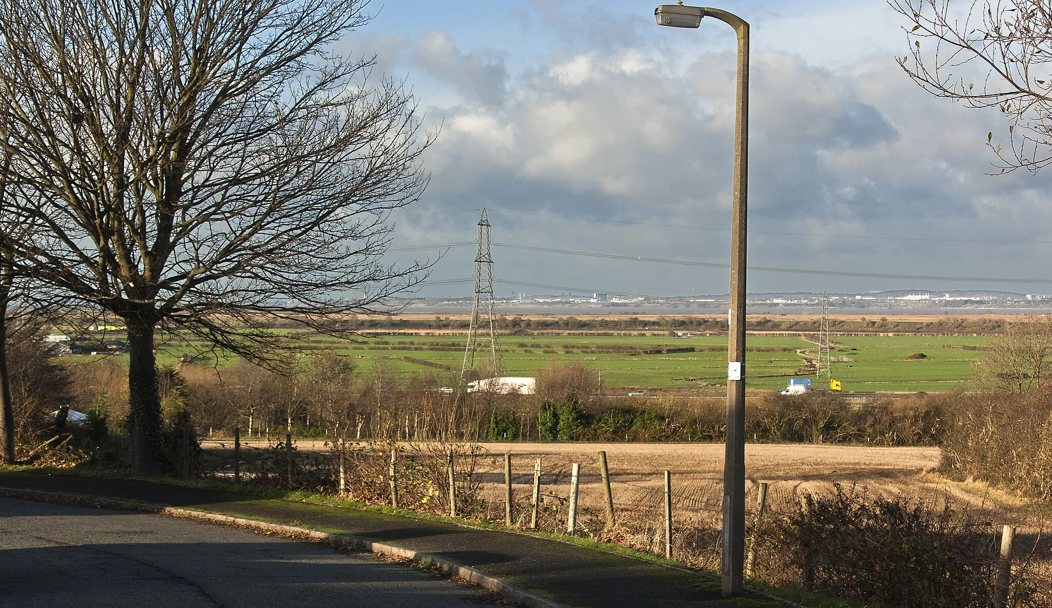 Photo showing: A view over the M56 to the River Mersey beyond