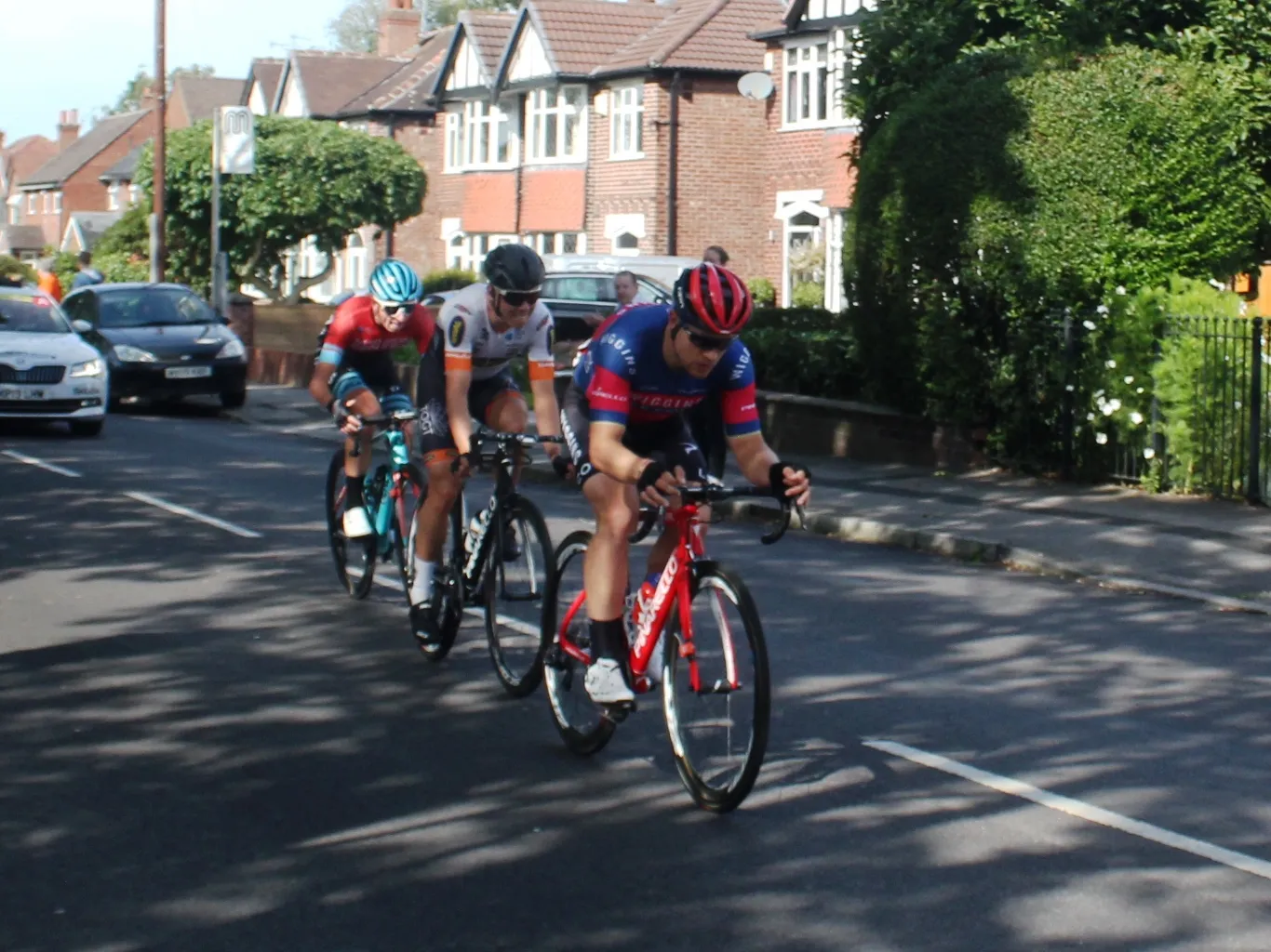 Photo showing: The final stage of the 2019 Tour of Britain saw the riders cycle through all ten of Greater Manchester's boroughs. It started in Altrincham and quickly saw a group of three riders breakaway. They are seen here passing through Hazel Grove in Stockport, with Gabriel Cullaigh leading Emil Vinjebo and Matt Holmes.