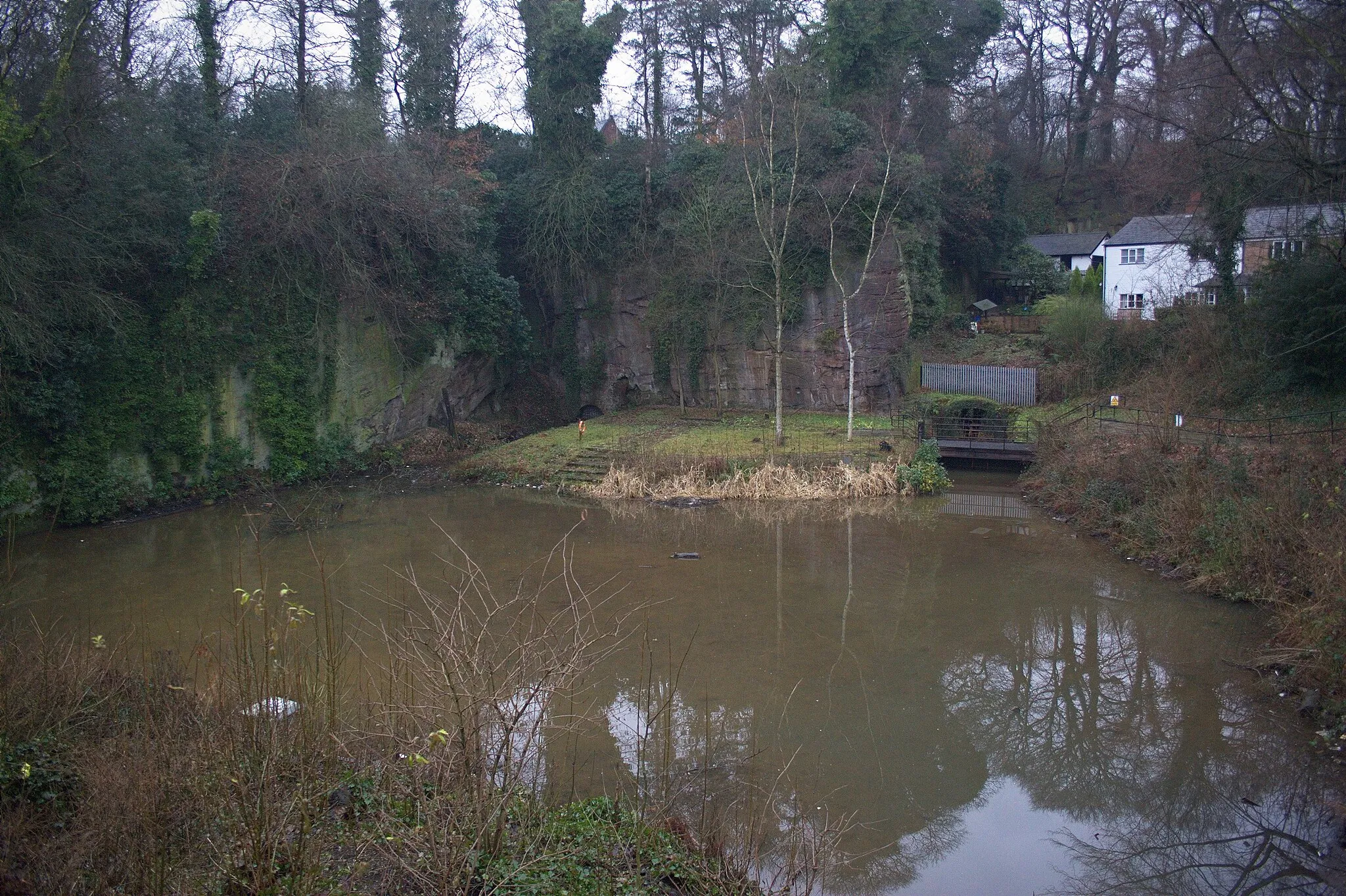 Photo showing: Worsley Delph, in Worsley, Greater Manchester.  The two entrances to the Duke of Bridgewater's mines are clearly visible.  The steps in the centre are a modern construction.  A Starvationer can be seen partially submerged against the wall on the left.