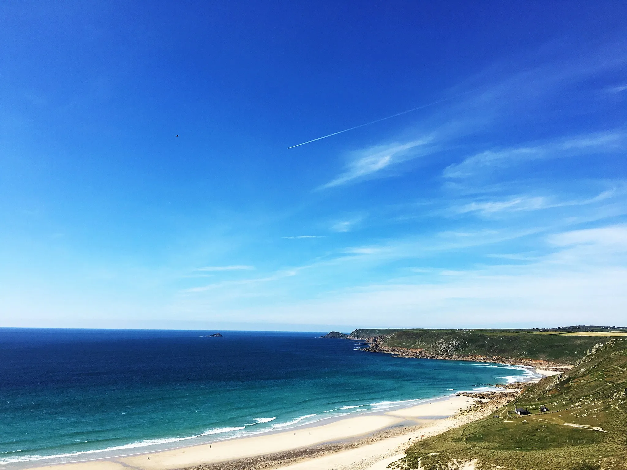 Photo showing: This is the beach at Sennen, also known as Whitesands Beach. The Atlantic swell provides the surf for which its noted. The view is looking down from Cove Road, showing the coastline with Cape Cornwall in the distance.