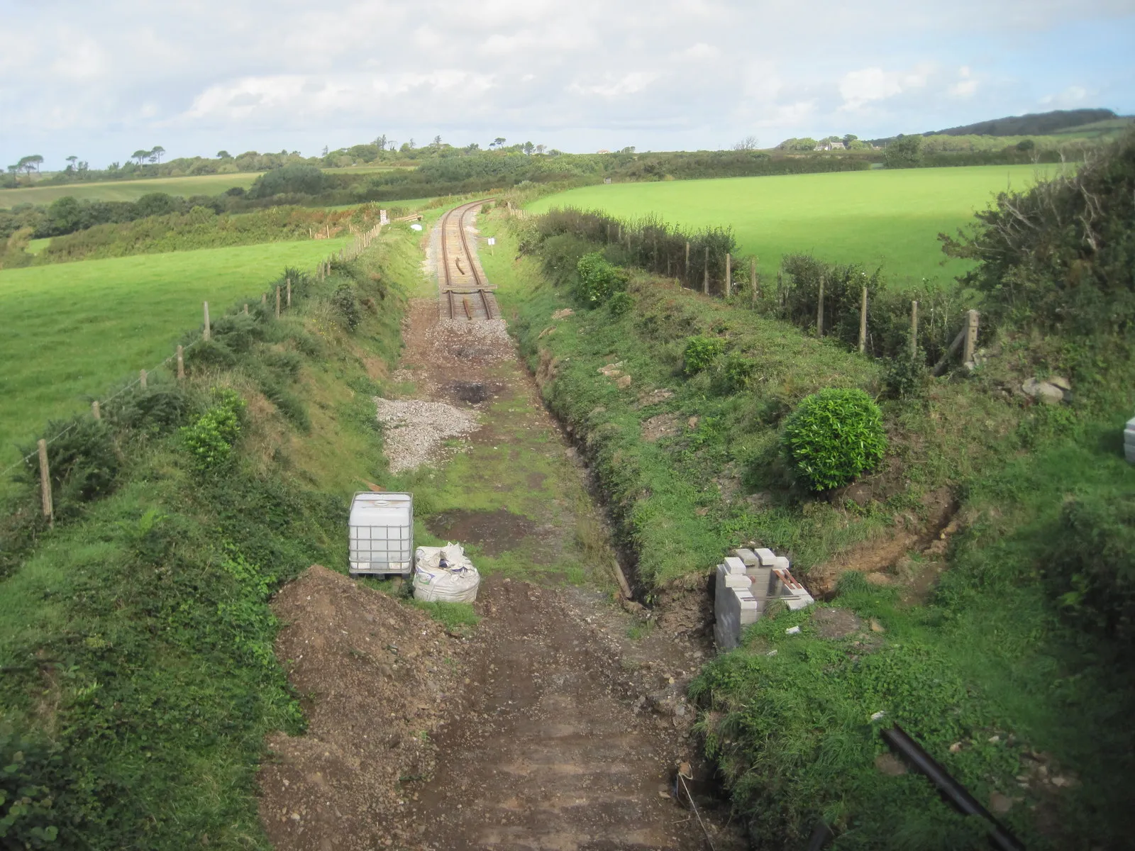 Photo showing: Truthall Halt railway station (site), Cornwall Opened in 1887 by the Helston Railway Company, later part of the Great Western Railway, on its line from Gwinear Road to Helston.
View north west towards Trevarno Platform and Gwinear Road. The modern Helston Railway Company was in the process of relaying track and rebuilding the Halt when this image was taken.
