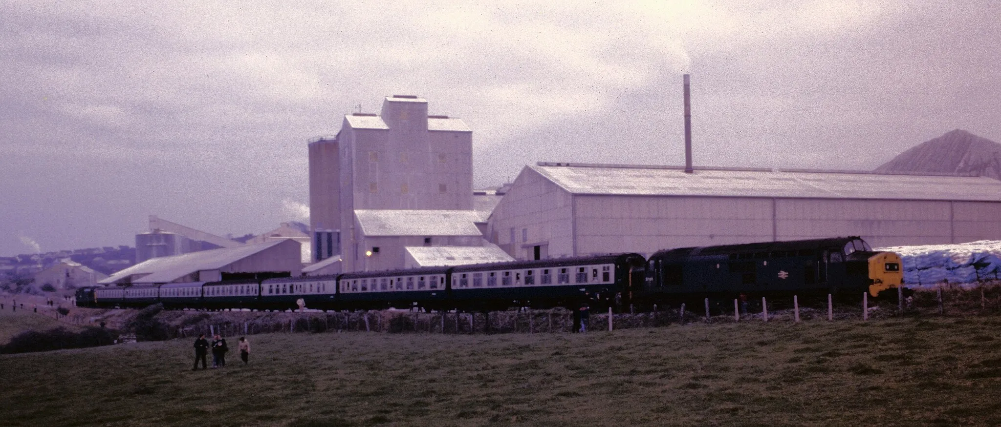 Photo showing: The BR organised Cornish Branches Railtour of 19 November 1983 stands at Parkandillack, with 37186 waiting to lead away back to the main line at Burngullow. 37187 was at the other end of the train, which also visited Carne Point, Bodmin General and Boscarne Junction in pre preservation days. One day I might rescan this, although I think that the slide may have deteriorated.