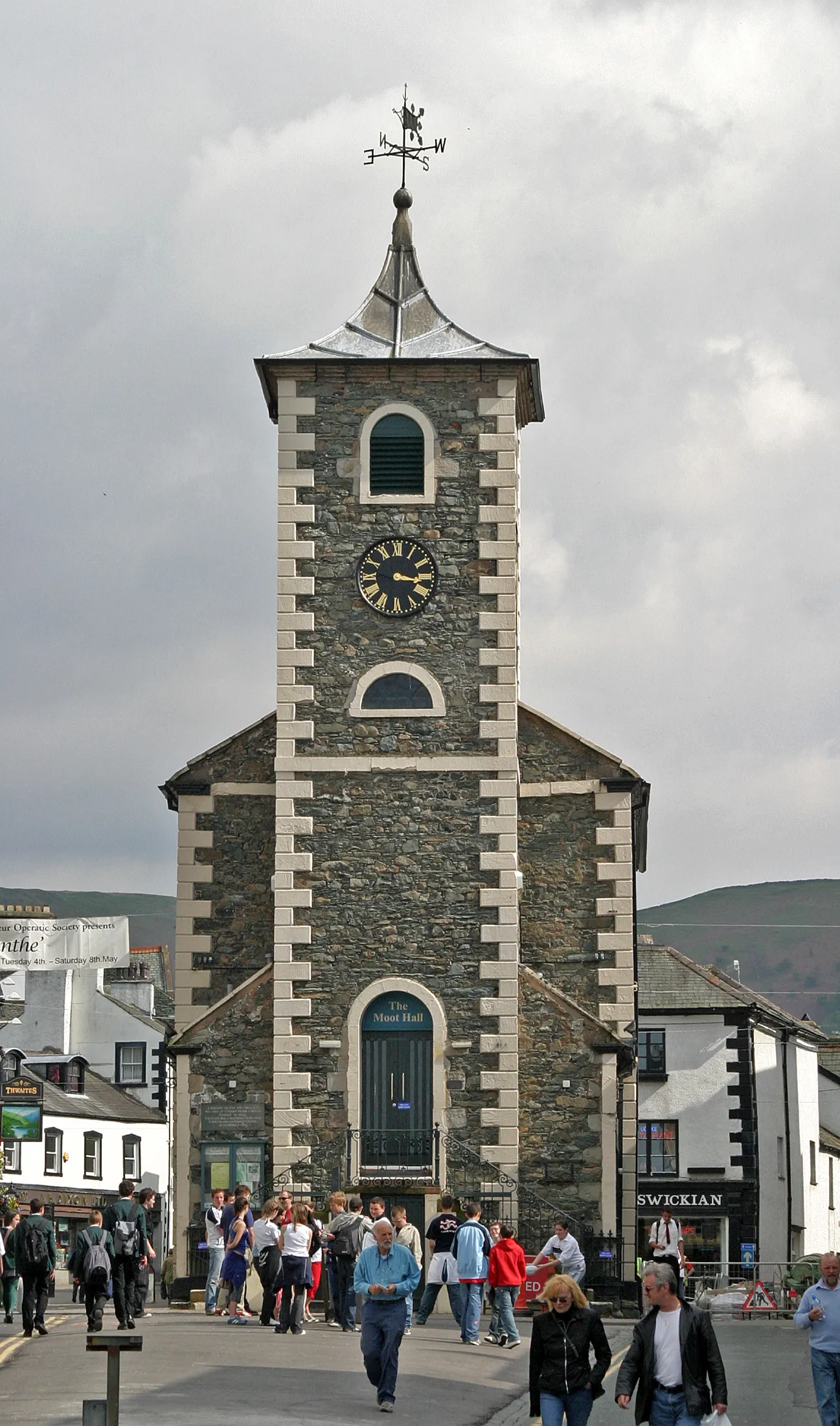 Photo showing: Market place with the Moot Hall in Keswick, a town with about 5,000 inhabitants in the northern English Lake District in County Cumbria. The Grade II Listed limestone and slate Moot Hall was built in about 1814 on the site of an earlier courthouse.