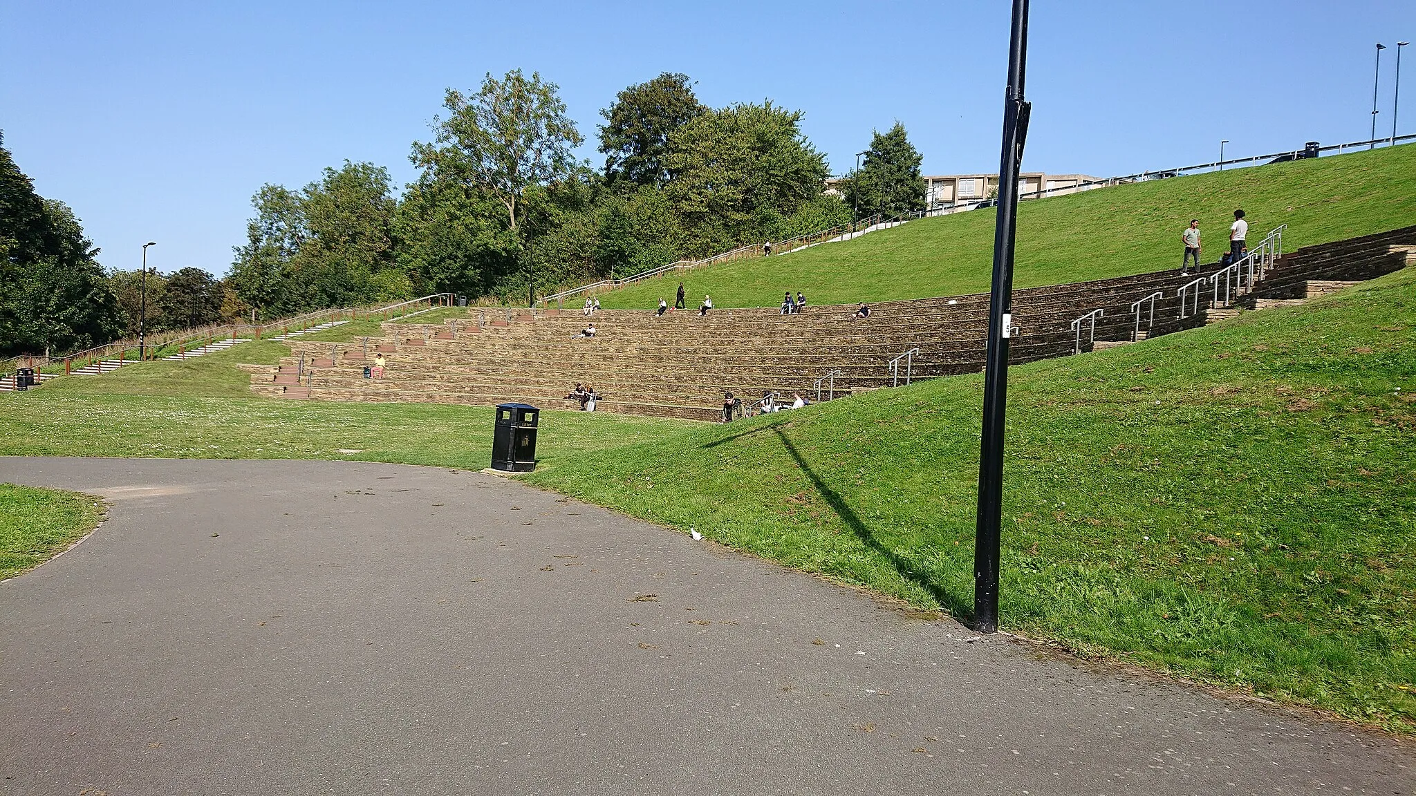 Photo showing: View of the Sheffield Amphitheatre from the south. Trees of Sheaf Park are visible in the background. Part of Park Hill Flats is visible behind the forground pole.