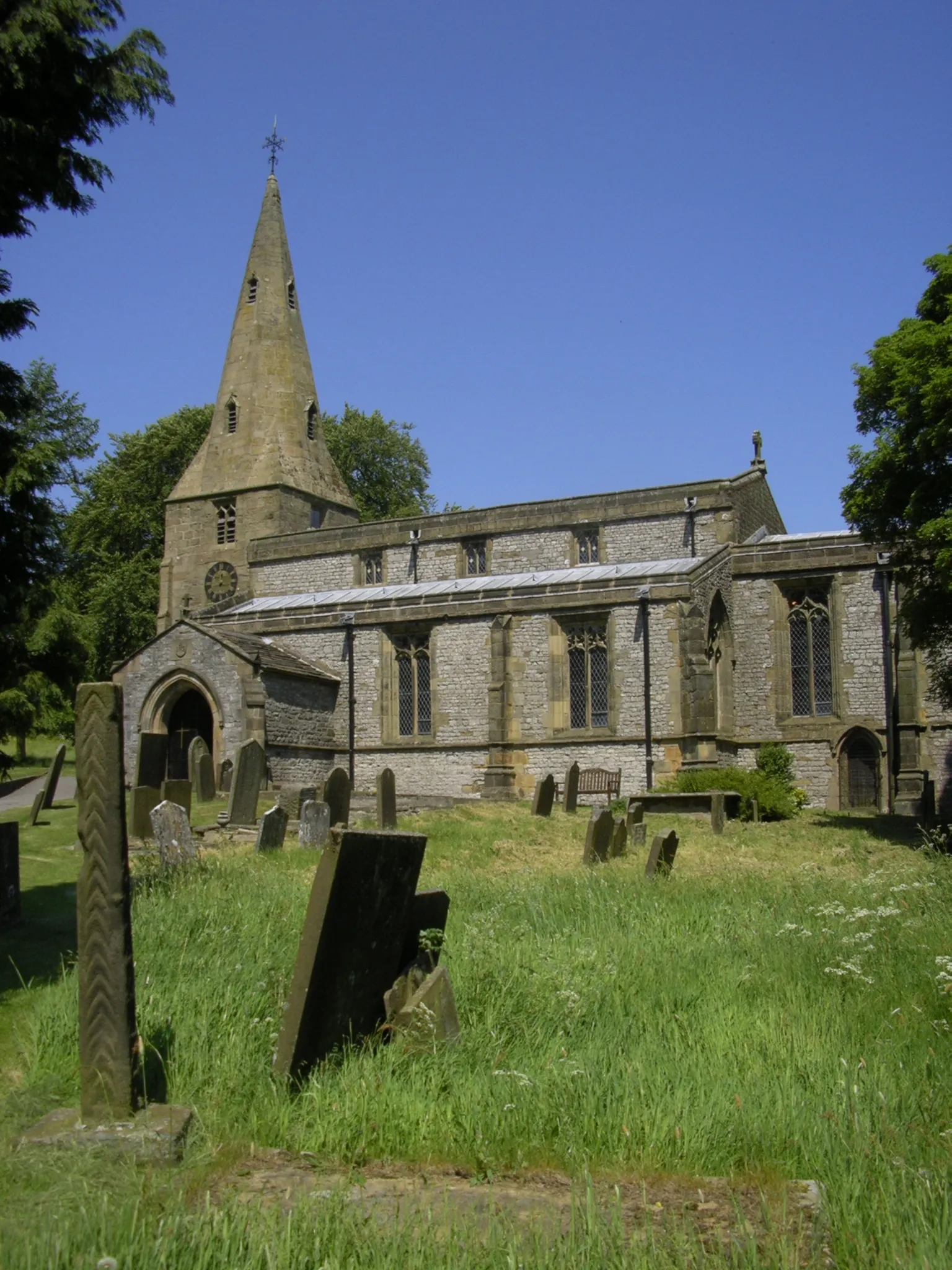 Photo showing: Church at  in Derbyshire, from the south; the remains of the cross are on the left.