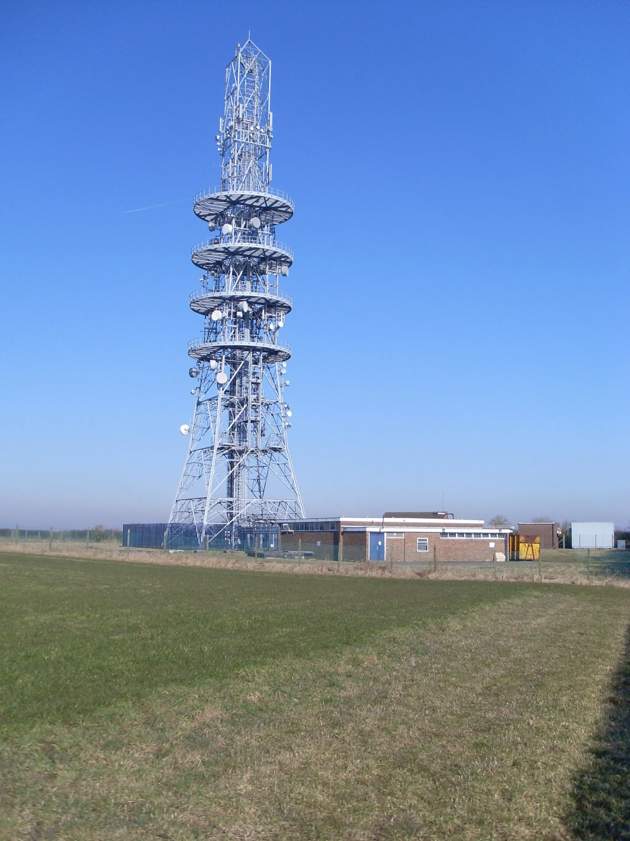 Photo showing: BT Radio Station, Tuxford. Situated off the A6075 Ollerton Road, this radio station is one of several in the United Kingdom providing microwave links for telecommunication, radio and television usage. Also, it is fitted with red aircraft warning lights, which means it can be seen at night for miles around. Its postcode is NG22 0PD.