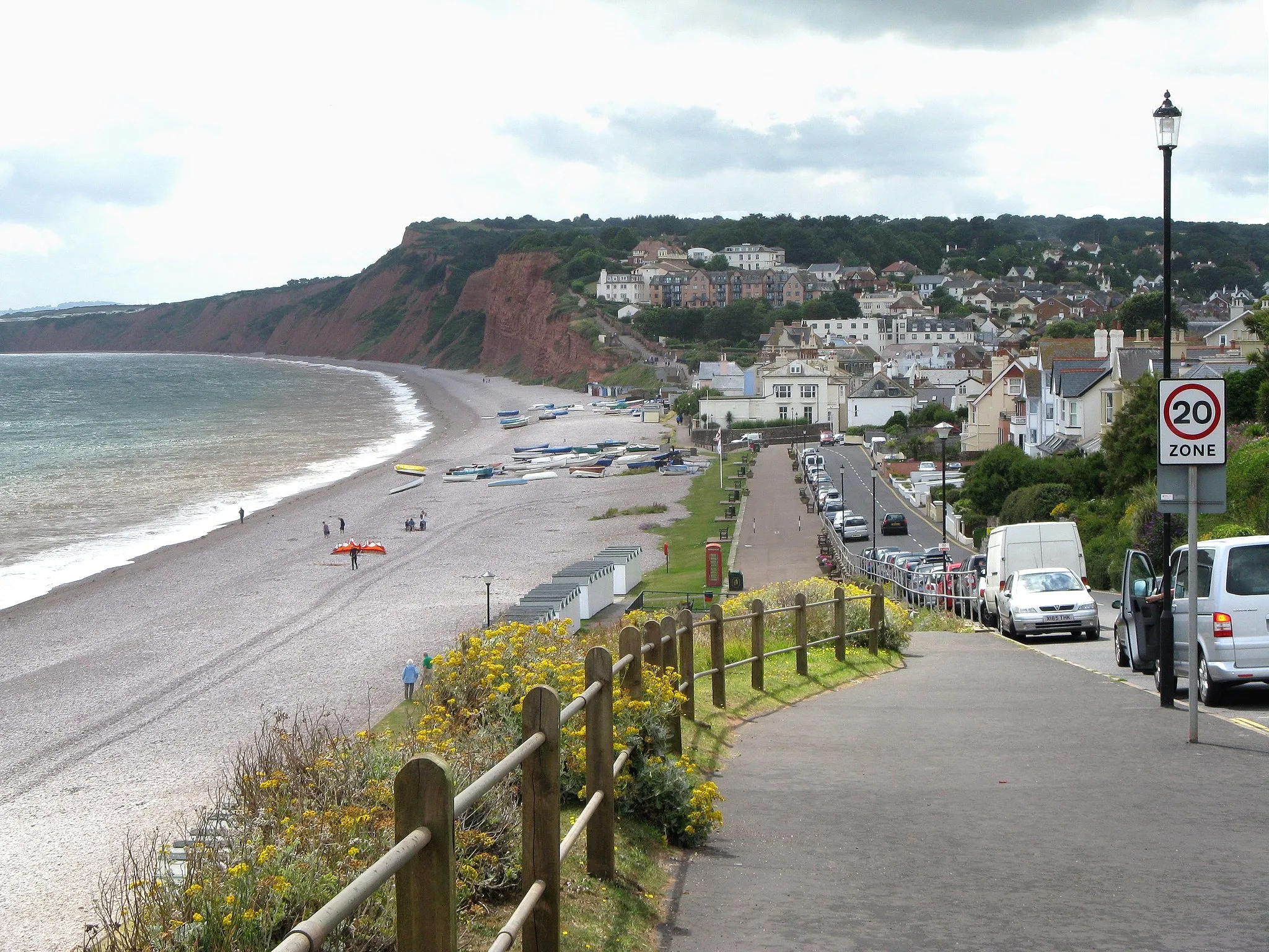 Photo showing: The sea front at Budleigh Salterton, South Devon, England, looking west. 
The red cliffs visible are of Triassic age (200-250 million years old) formed when the area was a desert. This coastline (starting at nearby Exmouth in Devon, and extending 95 miles (155km) to Swanage in Dorset) is the Dorset and East Devon World Heritage Site. The Heritage Site is also called the Jurassic Coast, although Triassic, Jurassic and Cretaceous periods are represented.
The orange object on the beach is a deflated kitesurfing kite.

Photographed by Adrian Pingstone in July 2009 (on a chilly Monday before the school holidays hence so few people) and placed in the public domain.