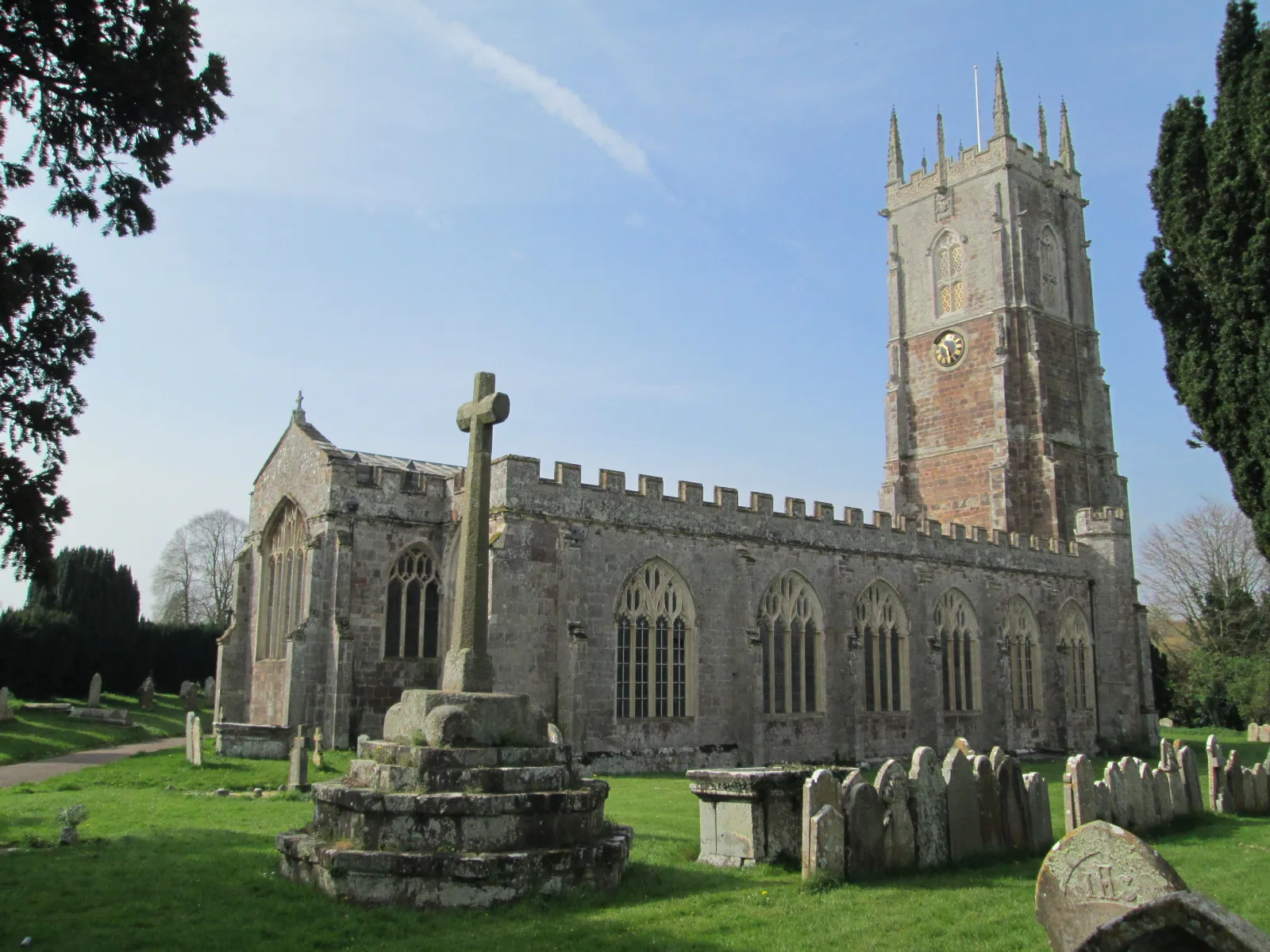 Photo showing: St John the Baptist's Church, in Broadclyst, Devon, viewed from the north-east, and the churchyard cross.