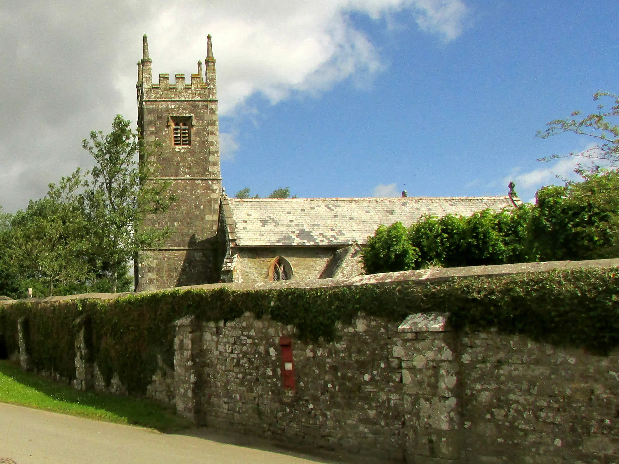 Photo showing: Churchyard wall and church from the south.