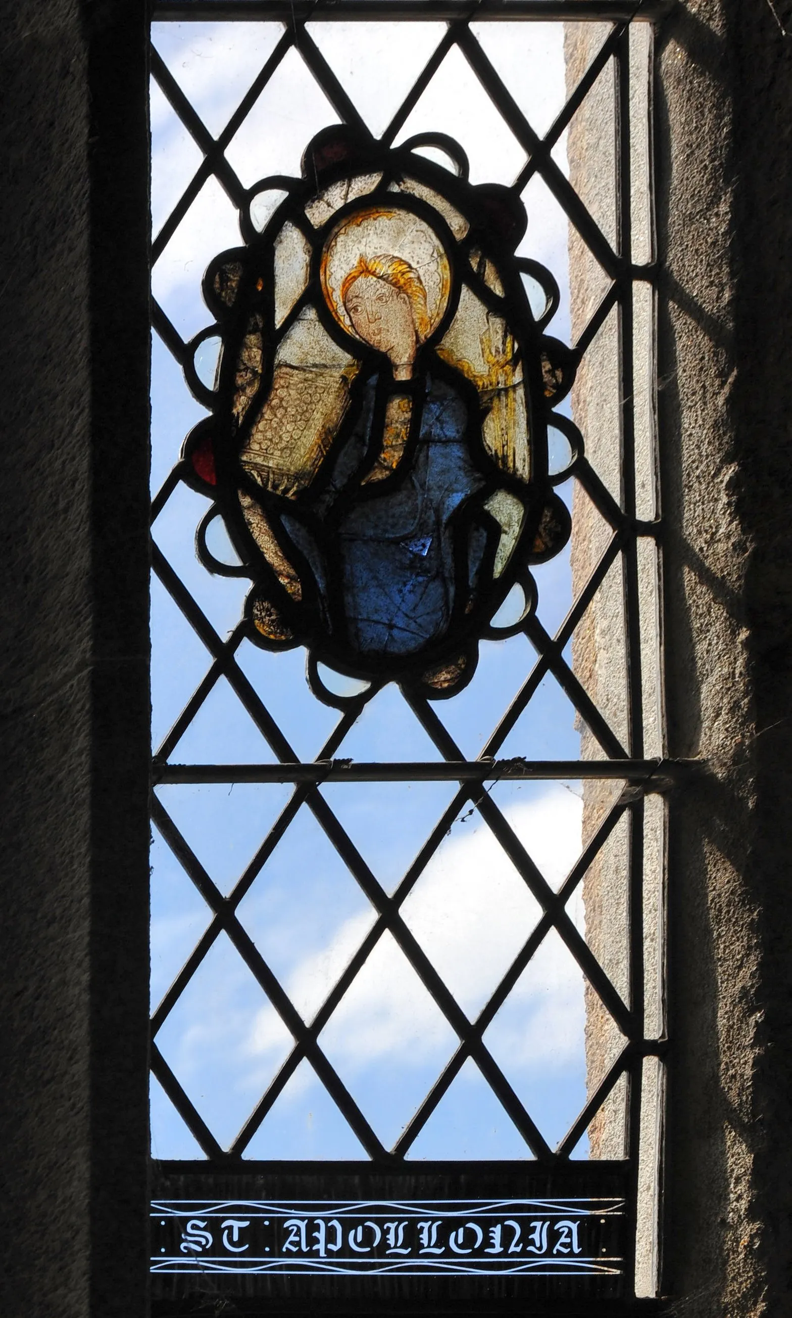 Photo showing: The stained glass image of Saint Apollonia in Kingskerswell church, Devon, England. (Perspective corrected)