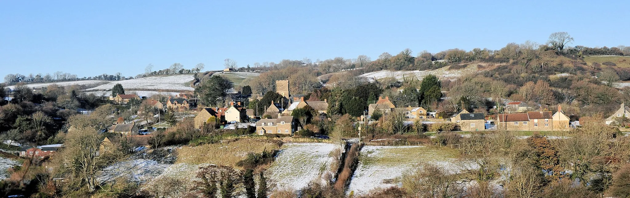 Photo showing: Panoramic view of the village of Powerstock in Dorset, England, taken from the top of Welcome Hill using a Nikon D700 and 50mm lens at f/11, 1/500s