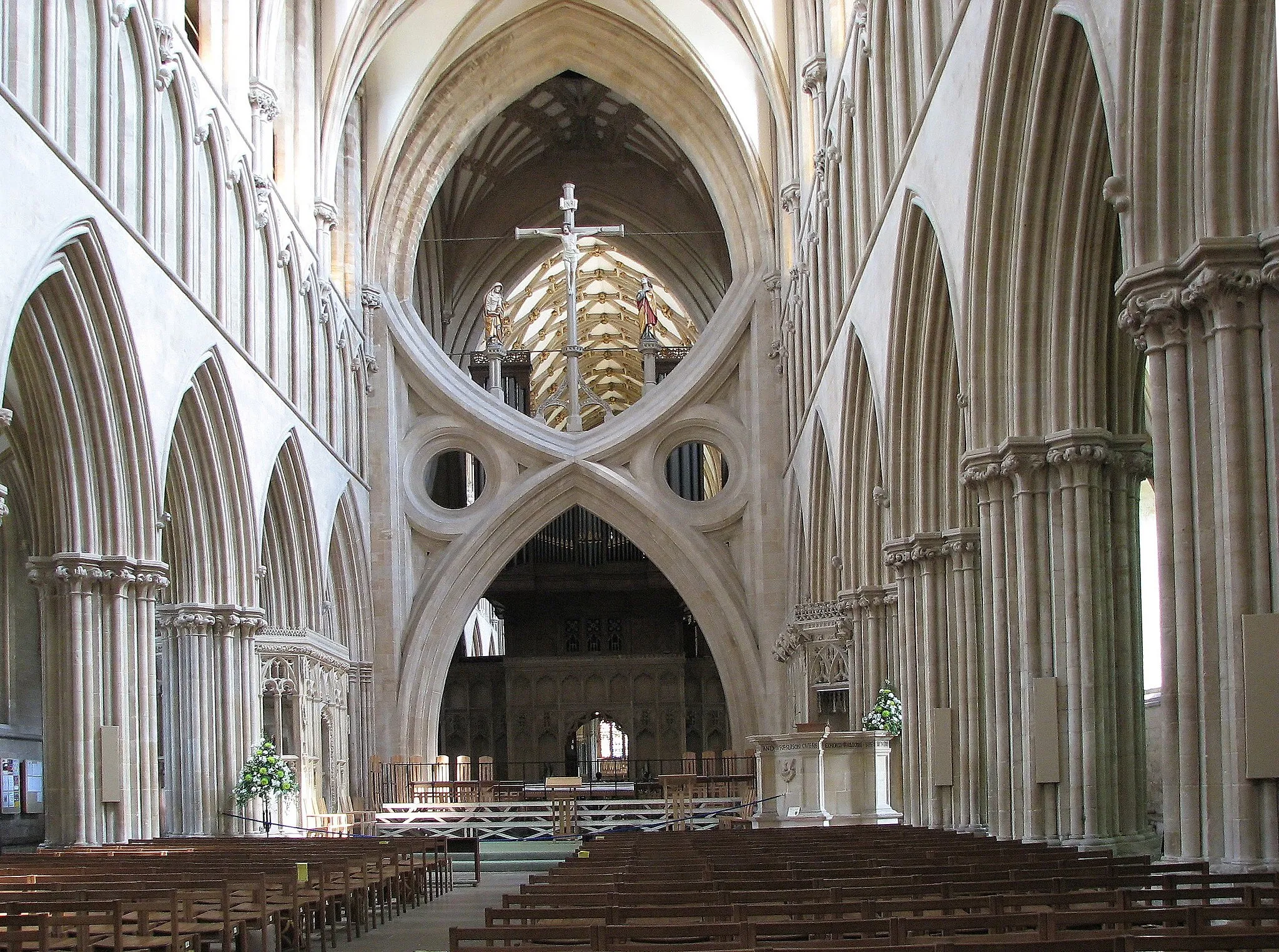 Photo showing: Interior of Wells Cathedral, Somerset, England. In 1338, to strengthen the cathedral, low arches topped by inverted arches of similar dimensions were inserted, forming scissors-like structures. These “scissor” arches brace the piers of the crossing on three sides, while the easternmost side is braced by a choir screen.