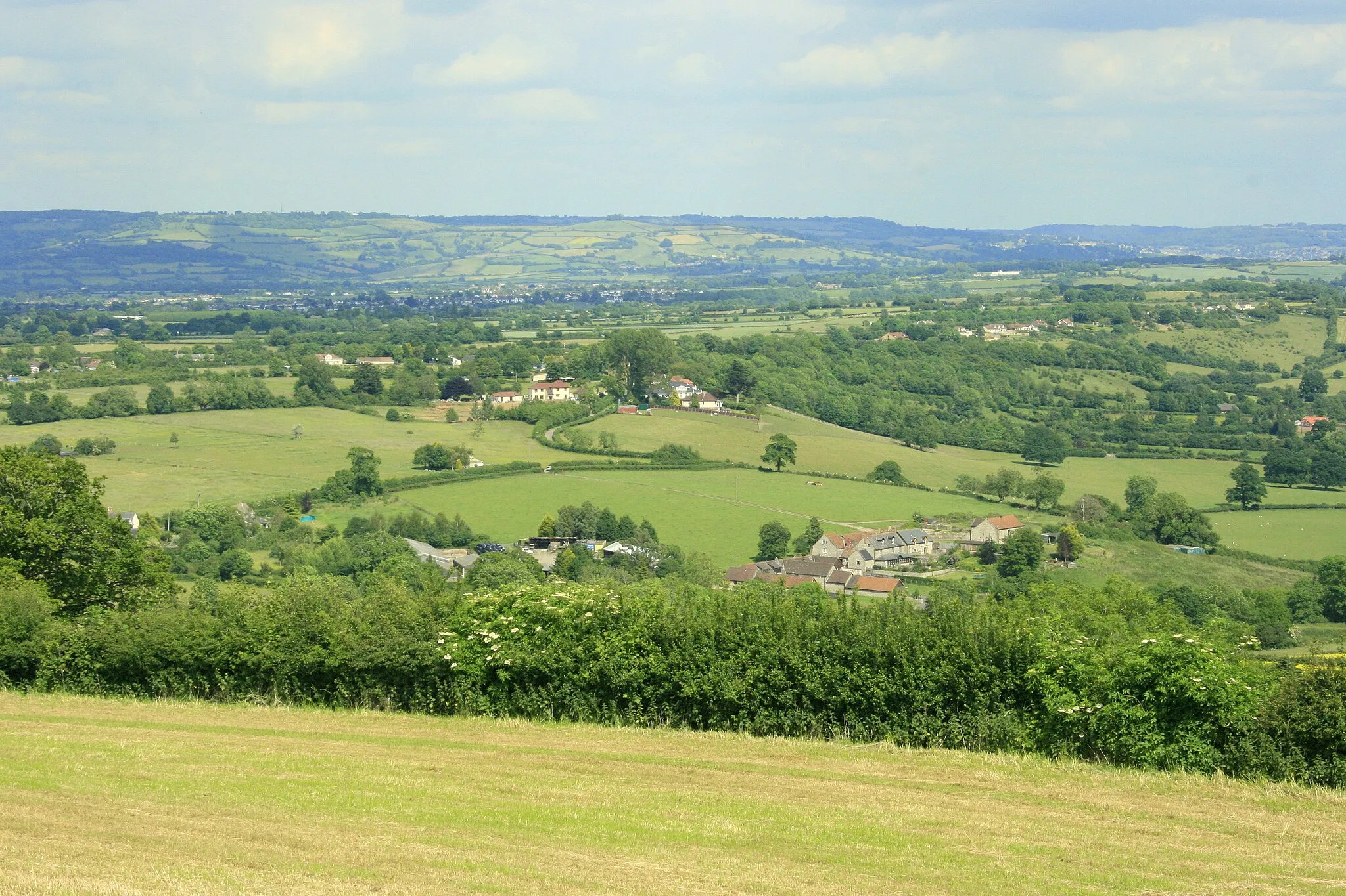Photo showing: East from Maes Knoll The eastern edge of the hill fort is in the foreground. New Barn Farm is to the right just above the hedgerow. Then houses at the top of Hursley Hill.
Lansdown is on the horizon with Beckford's Tower which you can almost see in this image.
Beckford's Tower ST7367 can be seen in the larger image.

------

"Legend gives us a pretty traditional and widespread 'earth from the spade' story. The story goes that a giant called Gorm (uuuum, Gorm? Gormless?) was wandering around with a load of earth on his spade. Not remembering what it was for he dumped it and made the tump on Maes Knoll."

Copied from: http://www.themodernantiquarian.com/site/2882/maes_knoll.html to which it was: Posted by pure joy