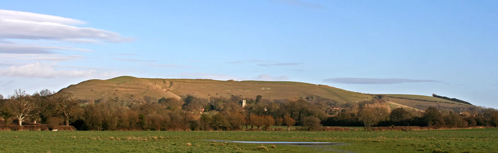 Photo showing: Hambledon Hill and Child Okeford in the early March sunshine from Netmead field, Dorset, England, UK.