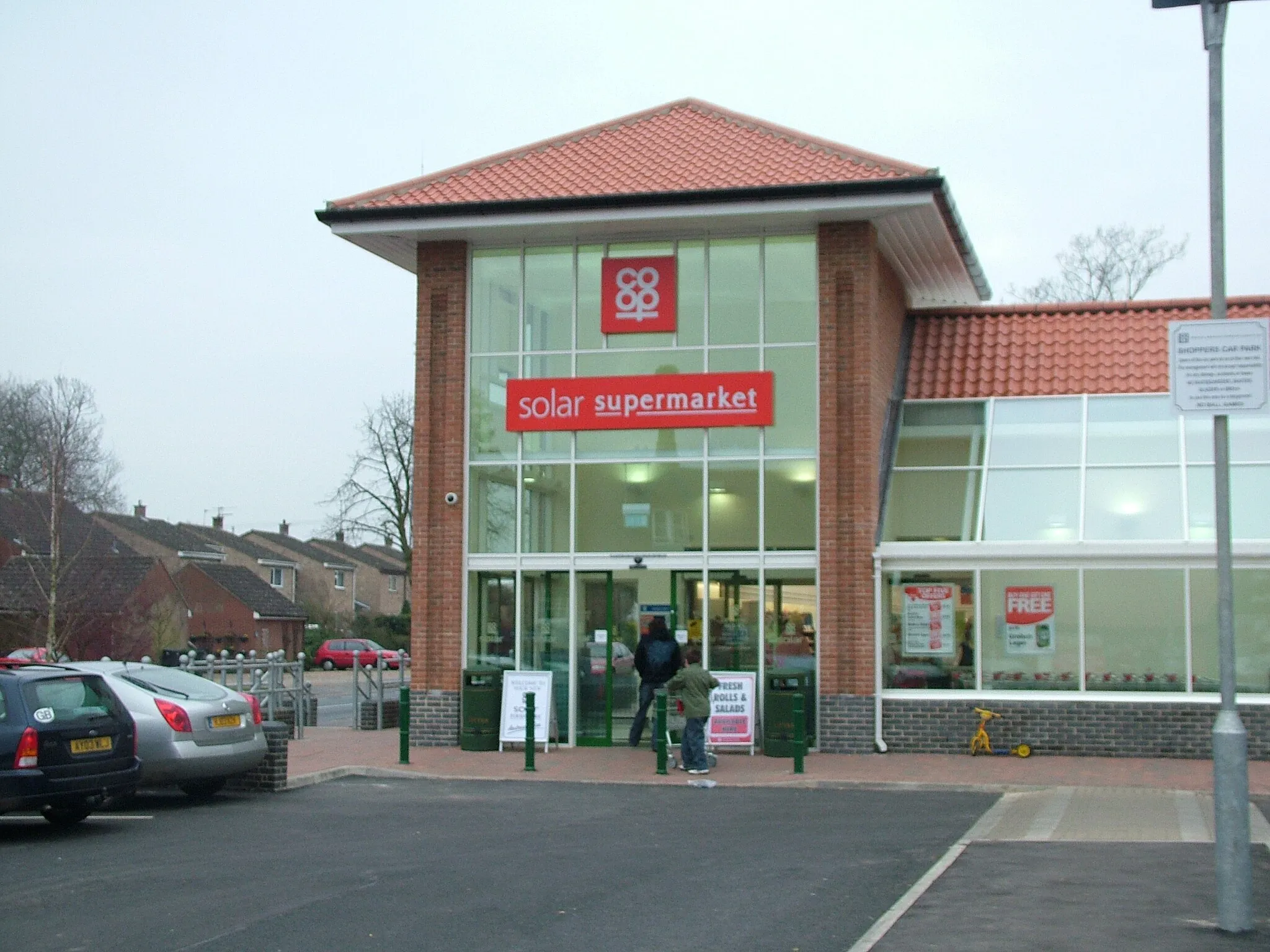 Photo showing: This is a picture of the Co-op solar supermarket in Long Stratton, Norfolk UK. The road in the background is the A140 - the major route in the area. Picture taken by Linden Parker, who releases it into the public domain.