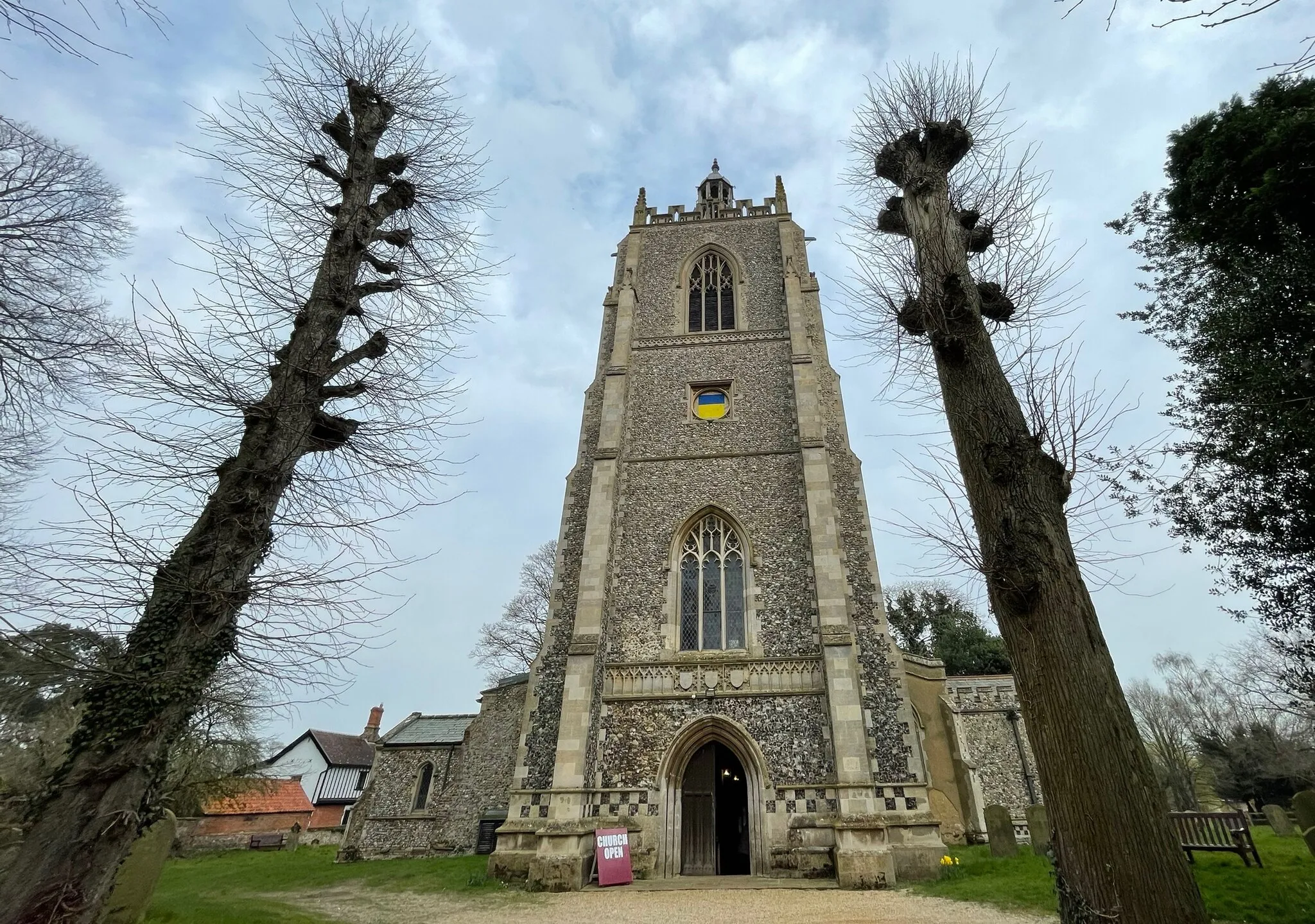 Photo showing: The tower at All Saints, Necton, but without the tower clock, which had been sent off for repairs. The space filled with the colours of the Ukrainian flag