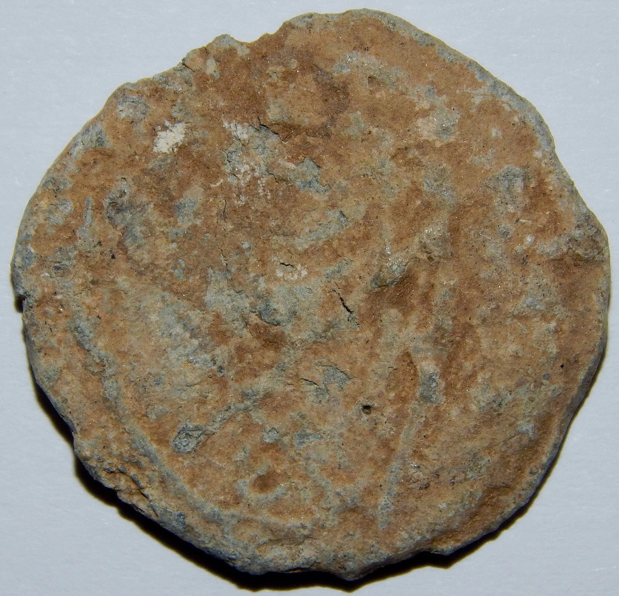 Photo showing: A Medieval circular bi-faced lead token, both sides have unidentifiable markings, diam 22 mm, weight 6.18g.