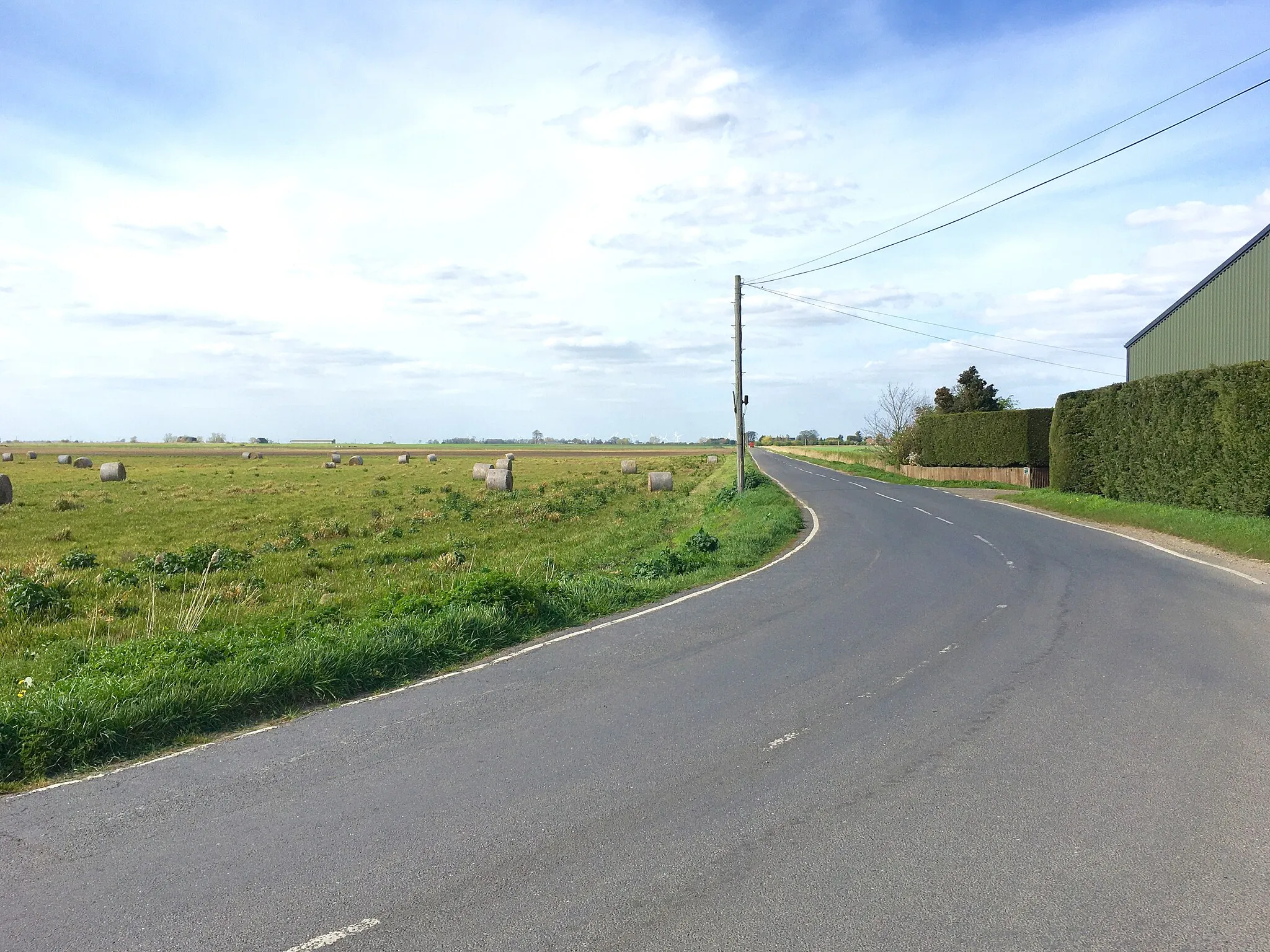 Photo showing: Looking towards Christchurch along Fifty Road from its right-angle bend by Burgess Farm, Tipps End, Norfolk, England.