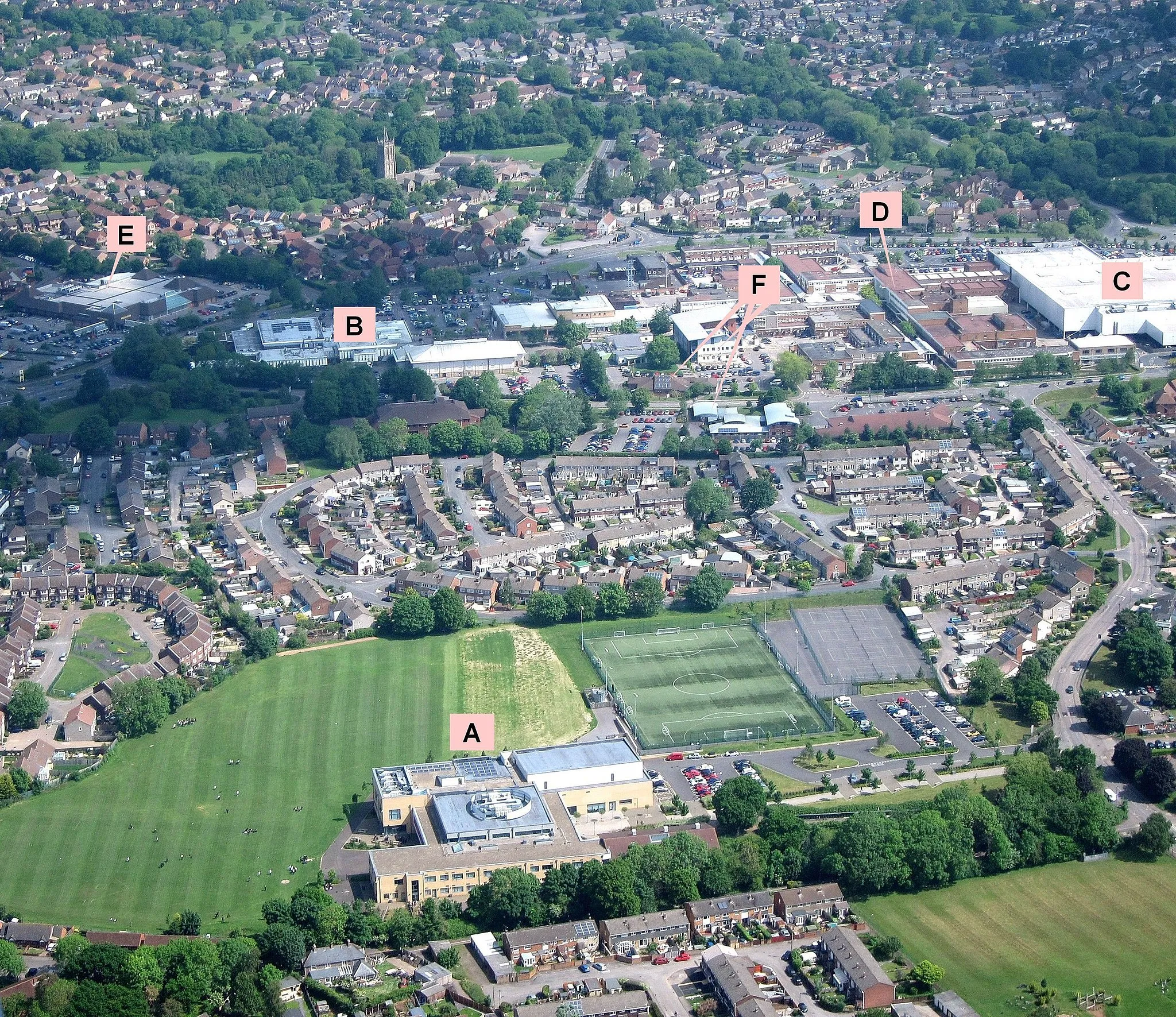 Photo showing: Part of Yate, South Gloucestershire, England. Taken from the (open) window of a Piper Cherokee Warrior during a pleasure flight from Gloucestershire Airport, Cheltenham. 
A = Yate Academy (a secondary school)
B = the Sports Centre 
C = Tesco, E = Morrisons (supermarkets)
D = Yate shopping centre

F = GP surgeries