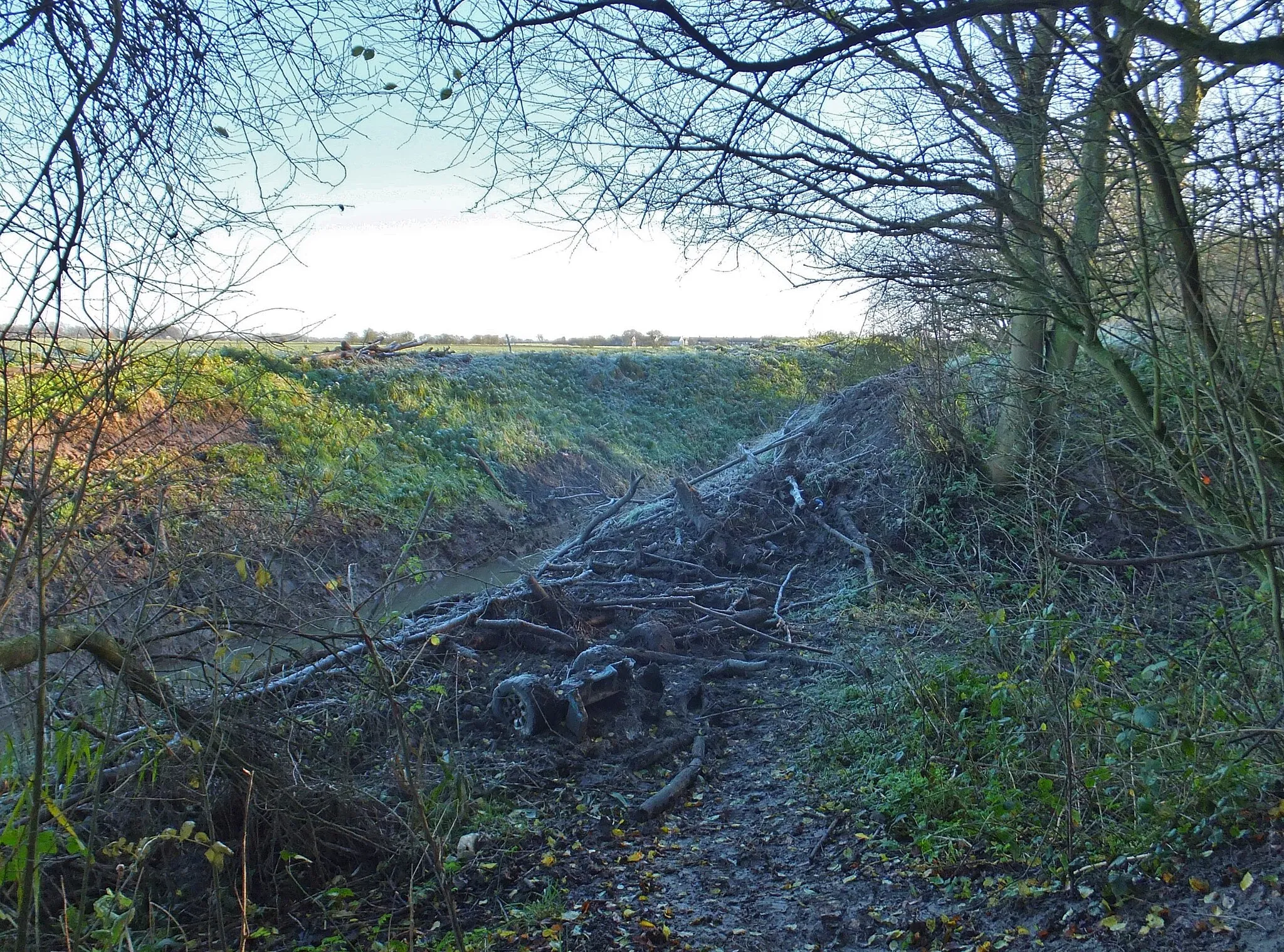 Photo showing: Ganstead Drain, Ganstead, East Riding of Yorkshire, England. Debris on the drain side consequential of dredging. To the east of the drain is farmland known as Low Grounds, Ganstead.