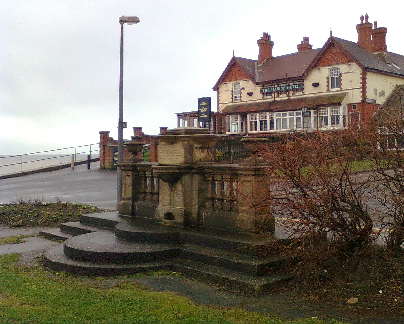 Photo showing: Hornsea Sea Wall and Promenade, Hornsea, East Riding of Yorkshire, England. Commemorating the opening of the Sea Wall and Promenade on 6th July 1907. The Marine Hotel is beyond.