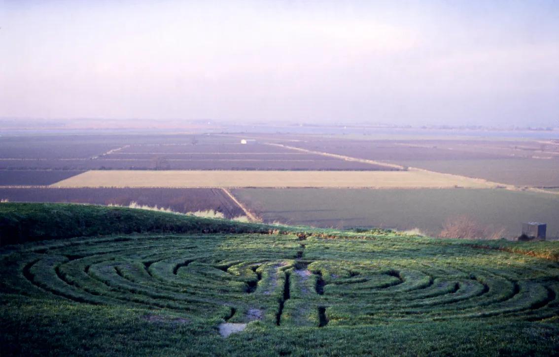 Photo showing: This is a scan of a transparency which I took in the 1970s. It has been slightly cleaned-up in Photoshop. It shows "Julian's Bower", the turf maze at Alkborough in North Lincolnshire, England, which overlooks the "Confluence of the Rivers" (where the rivers Trent and Ouse meet to become the River Humber). 
Alkborough Flats, the area of arable farmland in the valley below the maze, is to become an intertidal habitat from the end of 2006: it will allowed to flood periodically to encourage biodiversity and reduce pressure on flood defences elsewhere.
(Simon Garbutt, 8 Nov 2005)

(I retain the ownership and copyright of the original transparency and any higher-resolution scans derived from it) SiGarb 18:20, 8 November 2005 (UTC)