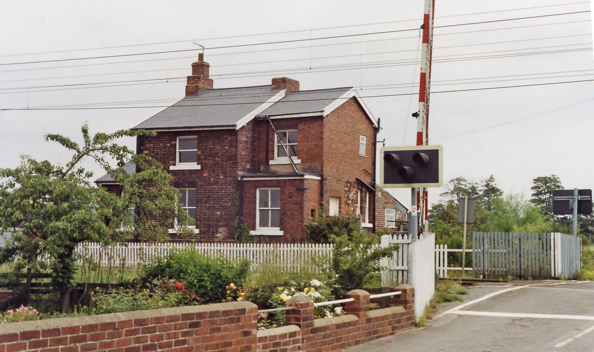 Photo showing: Balne: former station on the ECML, 1992.
View westward, ex-NER (Shaftholme Junction, Doncaster - to the left - York - to the right) section of the East Coast Main Line. The station was closed to passengers from 15/9/58 (to goods from 6/7/64), but in 1992 was clearly a pleasant private residence - hopefully with double-glazing, to keep out the noise of expresses rushing past - IC225 electric trains in recent years.