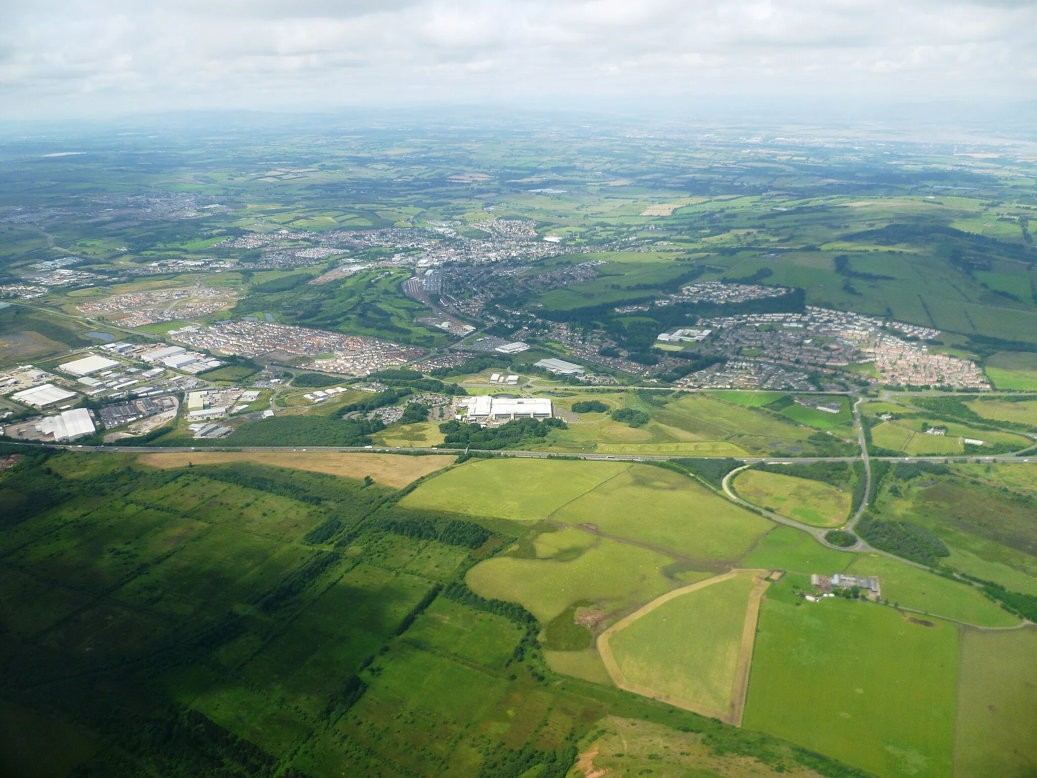 Photo showing: View of Bathgate, West Lothian from an aeroplane approaching Edinburgh Airport. The town can be seen on the north side of the M8 motorway with the Whitehill Industrial Estate on the left, the Pyramids Business Park in the centre and Boghall on the right.