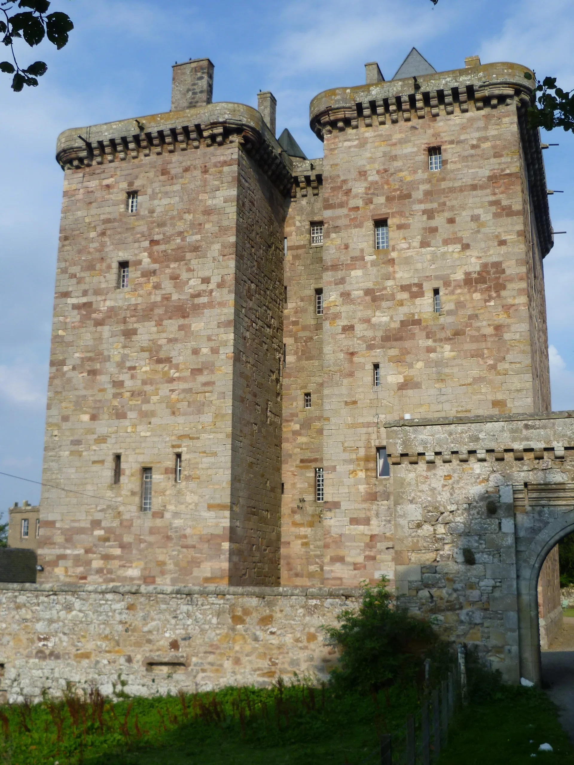 Photo showing: The fortified tower house was the classic Scottish solution to the problem of building defensible structures in a country where warfare was endemic for centuries. The Scottish Lowland landscape is peppered with many fine examples, to the extent that the 16thC historian, John Major, could write,
"There are in Scotland for the most part two strongholds to every league, intended both as a defence against a foreign foe, and to meet the first outbreak of a civil war." (History of Greater Britain, 1521).
Scotland's Stewart monarchs explicitly forbade the Scottish nobility to imitate the fortifications of their royal castles. Most 'castles' in Scotland are in fact tower houses which have been expanded by additional ranges which can often conceal the original tower at first sight. Borthwick is a unique example of twin towers.