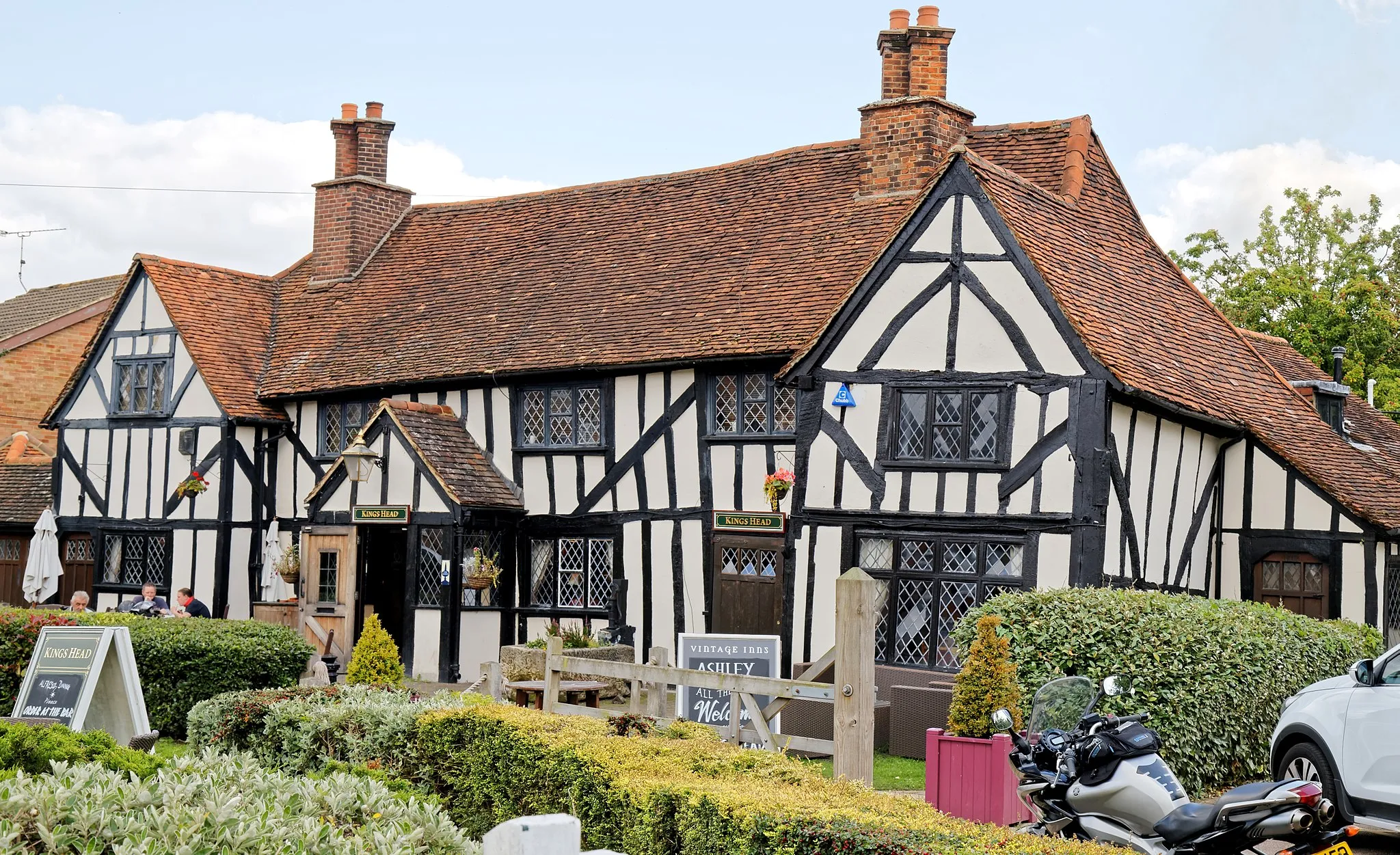 Photo showing: The Kings Head pub, High Road, North Weald, Essex, England, seen from the west. Software: RAW file lens-corrected, optimized and converted to JPEG with DxO OpticsPro 10 Elite, and likely further optimized and/or cropped and/or spun with Adobe Photoshop CS2.